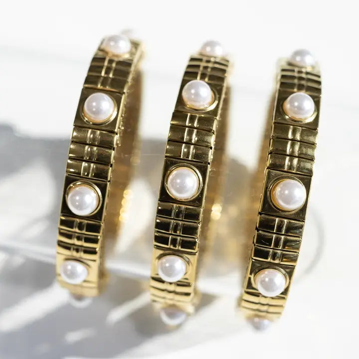 Three 18K gold plated bracelets featuring a link chain design with inlaid pearls. The bracelets are stackable and waterproof.