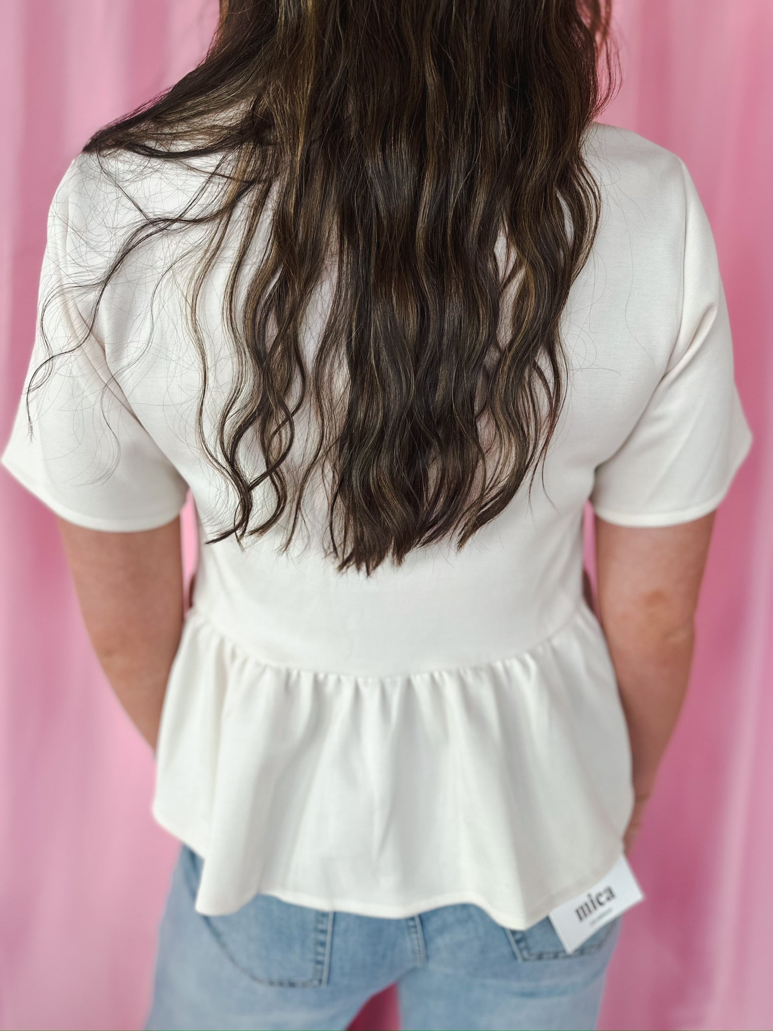 Entro cream jeweled button peplum jacket, short sleeves, gathered waist, and peplum hem. Back view.