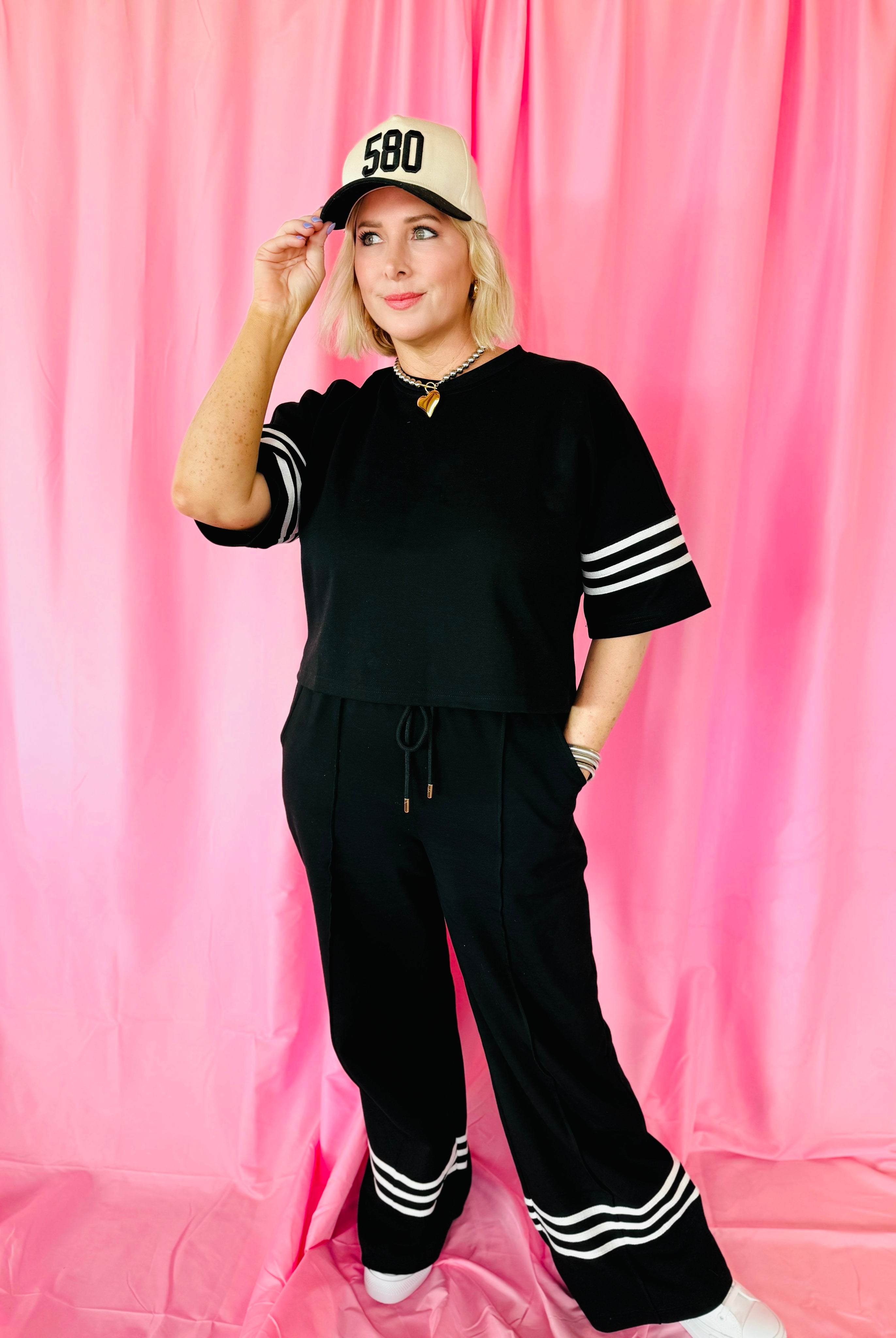 Woman models Black & White Stripe Entro Matching Set: cropped top with striped sleeves, wide-leg pants with white stripes