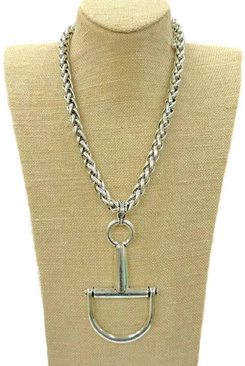 Large silver horse bit necklace with a thick, braided chain, displayed on a mannequin bust.