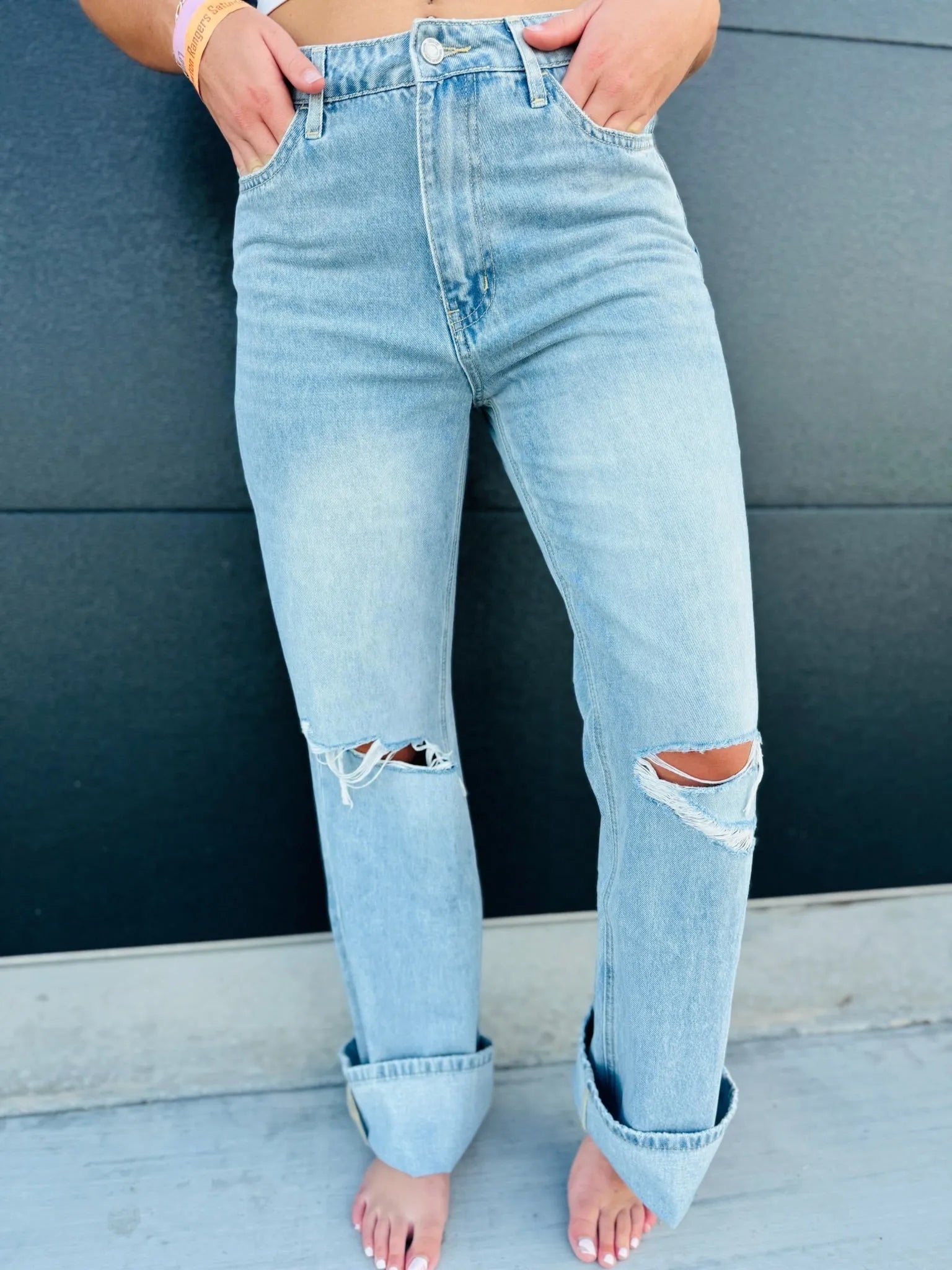 Light wash denim 90s vintage super high rise jeans with distressed ripped knees and cuffed hems.