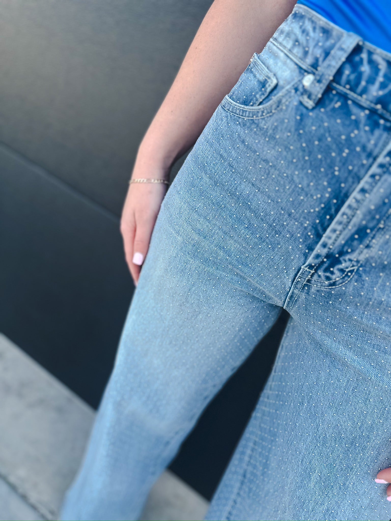 Light wash denim wide leg jeans with all-over micro stud embellishments. High-rise waist with front pockets and a slouch fit.