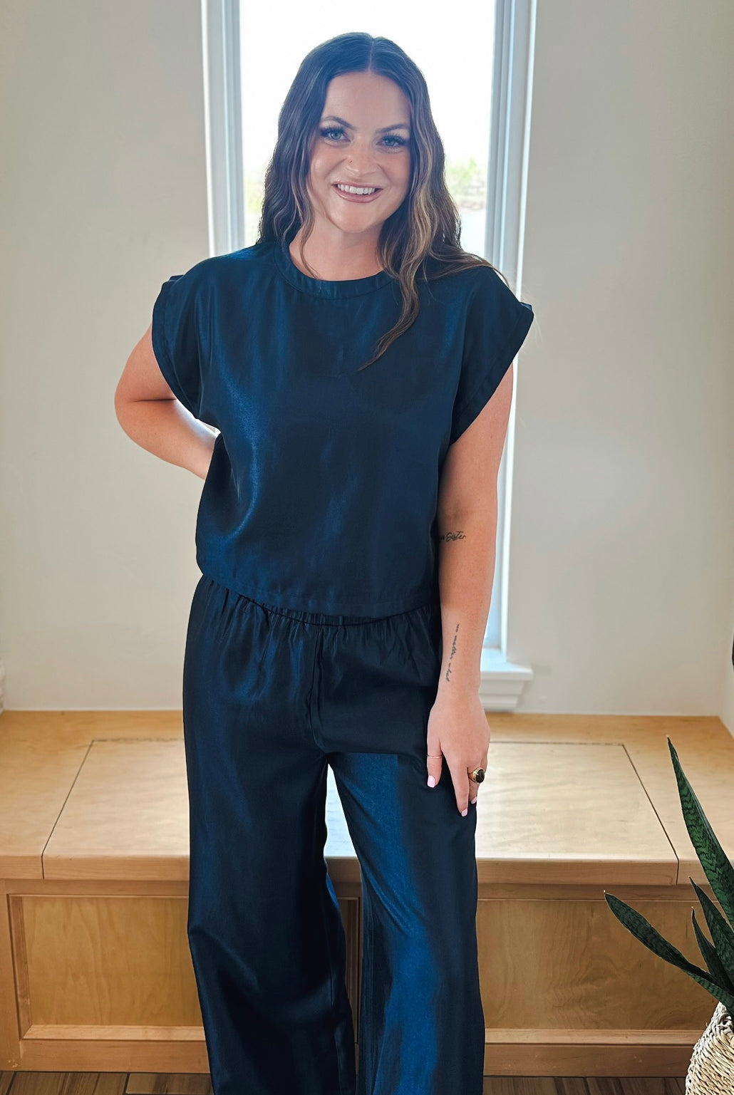 Navy shimmer matching set: short sleeve top with elastic waist and wide leg pants on a smiling woman.