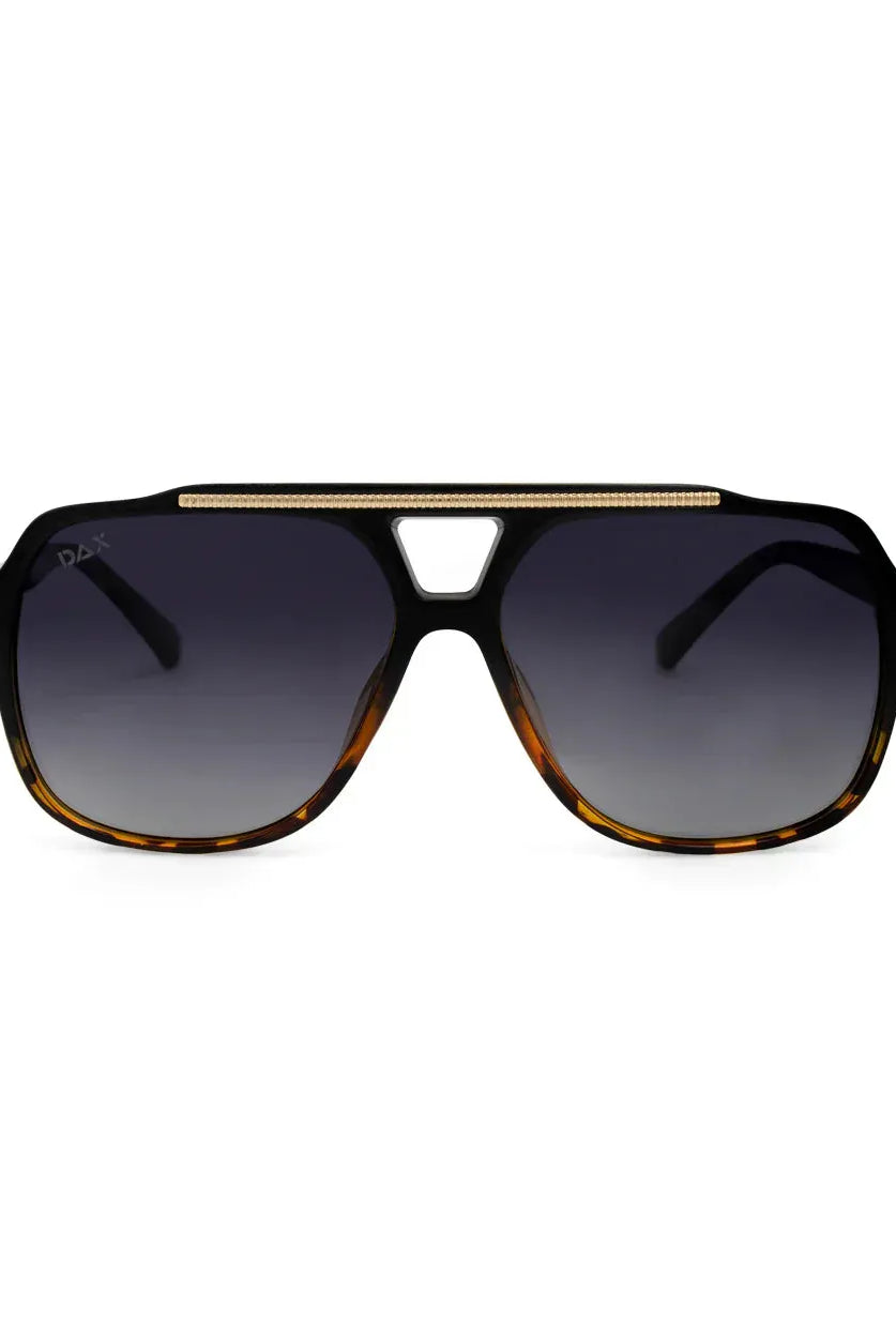 Oversized aviator sunglasses with black frames, tortoiseshell accents, dark gradient lenses, and a gold textured double