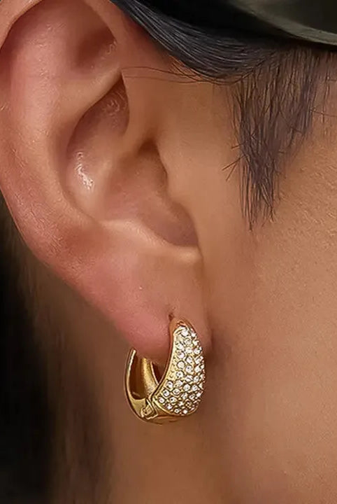 Aurven 18K gold teardrop hoop earrings with pave crystal detailing on a model's ear.