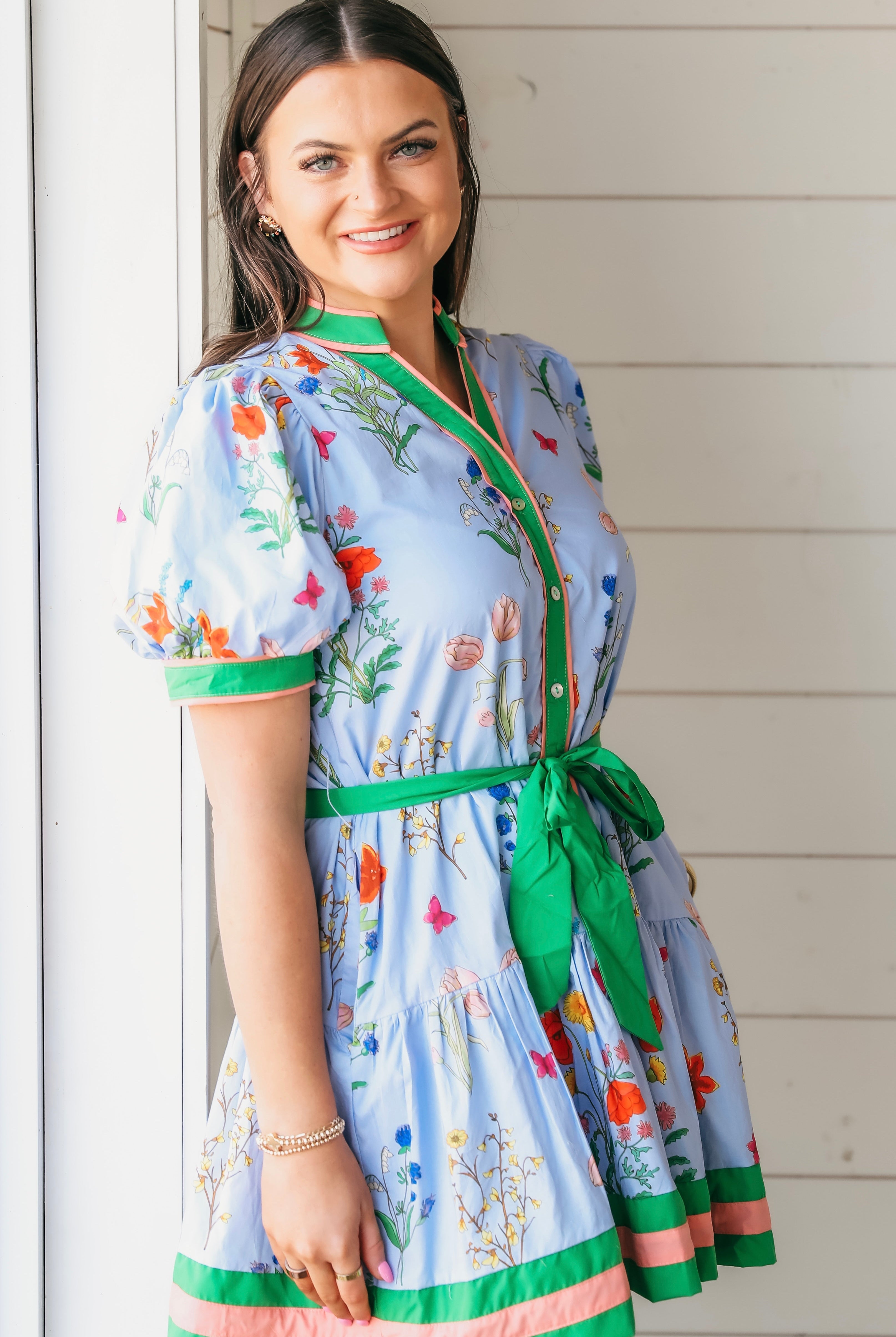 Blue Entro floral print dress with puff sleeves, green collar, and pink and green trim. A green tie belt cinches the waist.