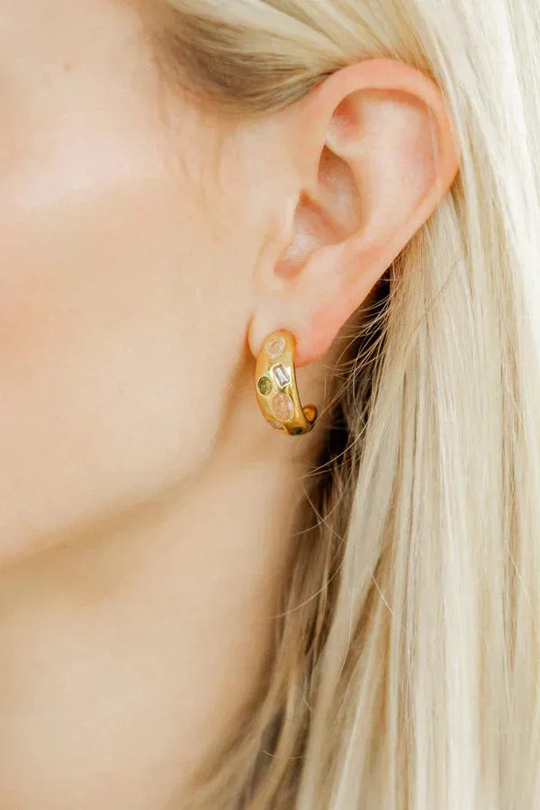 Gold plated hoop earrings featuring inlaid multi-color stones in round and baguette shapes.