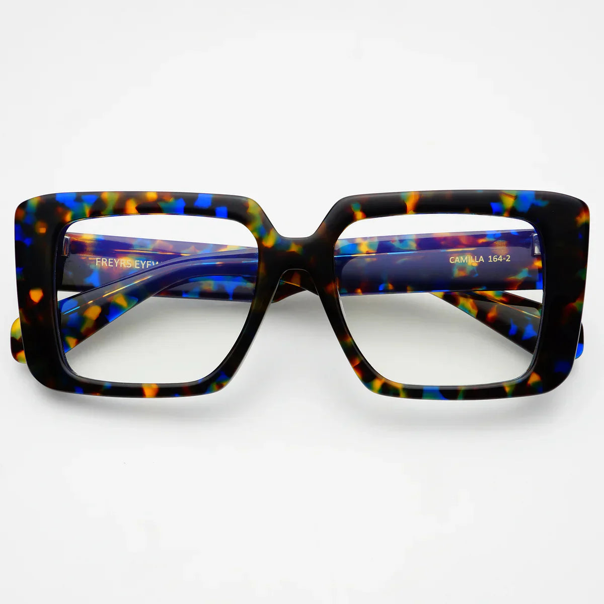 Camilla blue light reading glasses featuring oversized square tortoise shell frames with blue and orange accents. Clear