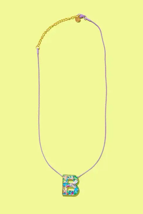 Confetti letter B necklace with a glittery resin pendant on a delicate purple chain with gold accents.