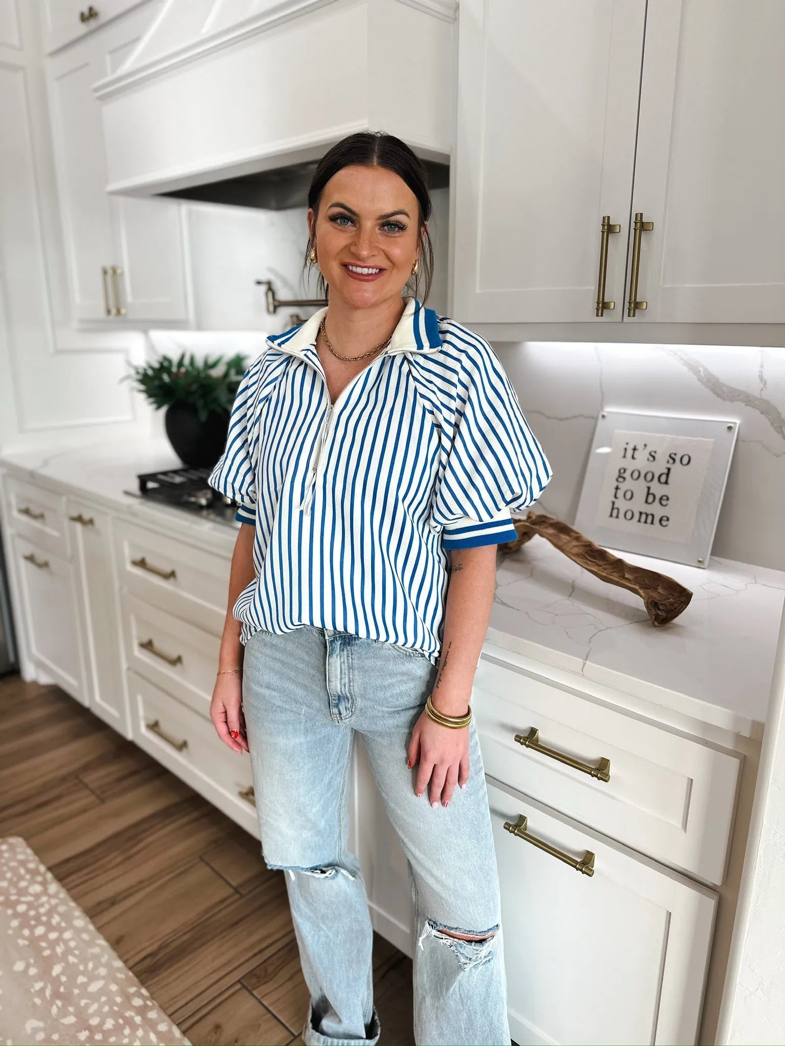 Entro blue and white vertical striped zip v-neck top with blue collar and cuffs. Paired with light wash ripped jeans.