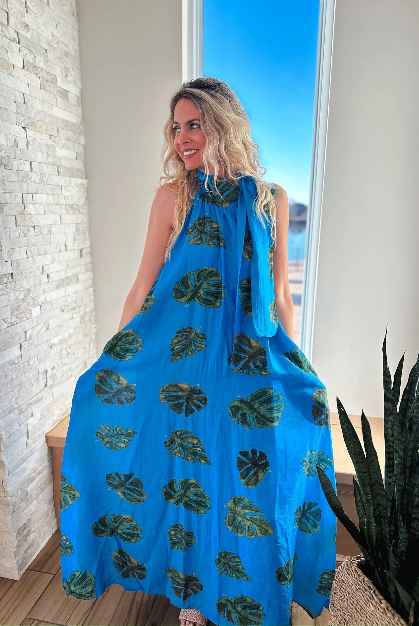 Entro blue maxi dress with a tropical palm leaf print and tie neck detail.