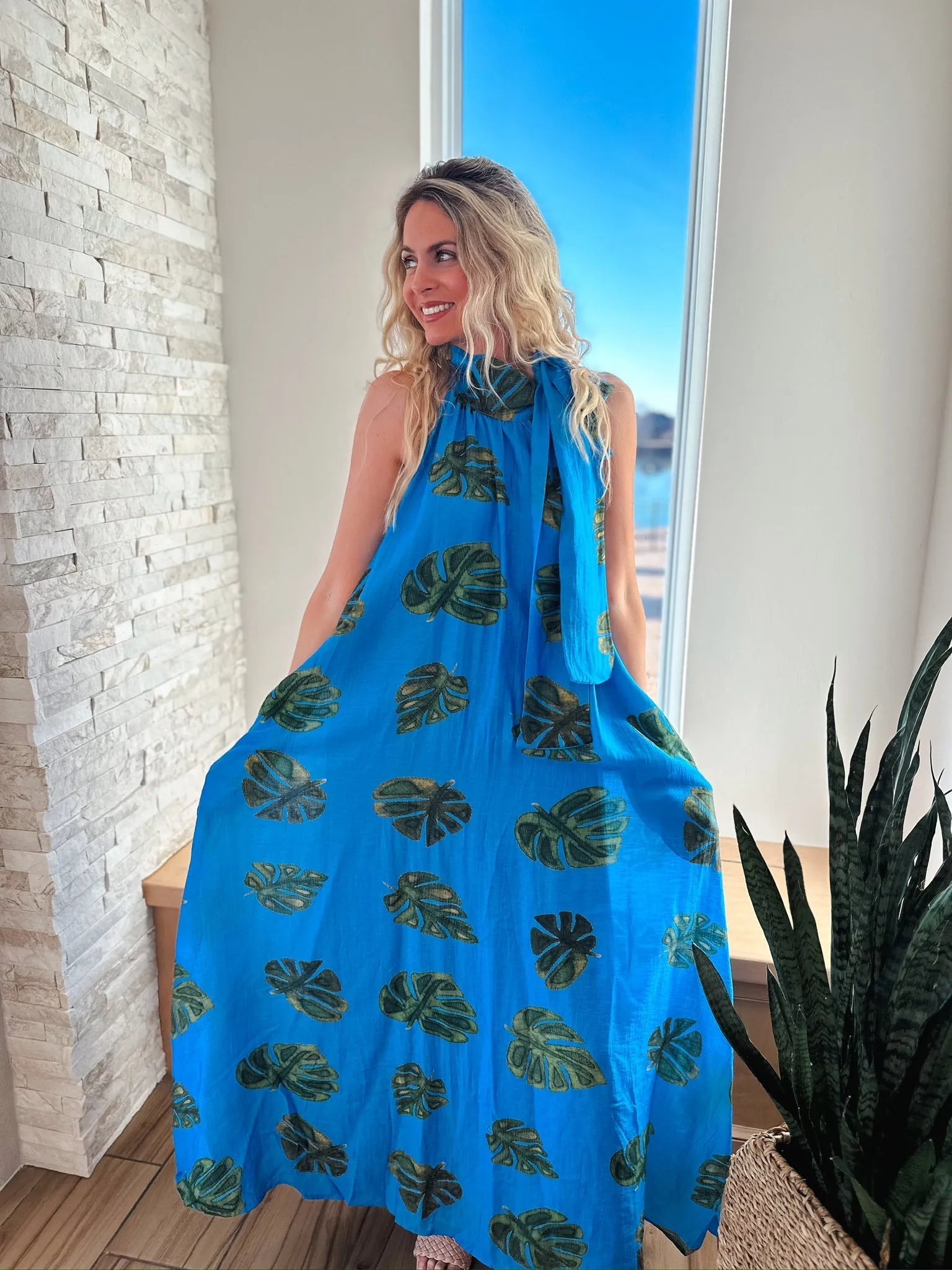 Entro blue maxi dress with a tropical palm leaf print and tie neck detail.
