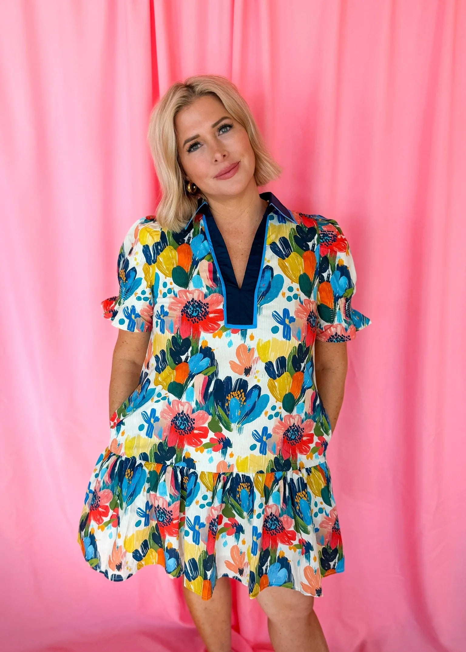 Entro blue spring flower dress with short puffer sleeves, V-neck, and tiered ruffle hem. White base with vibrant floral