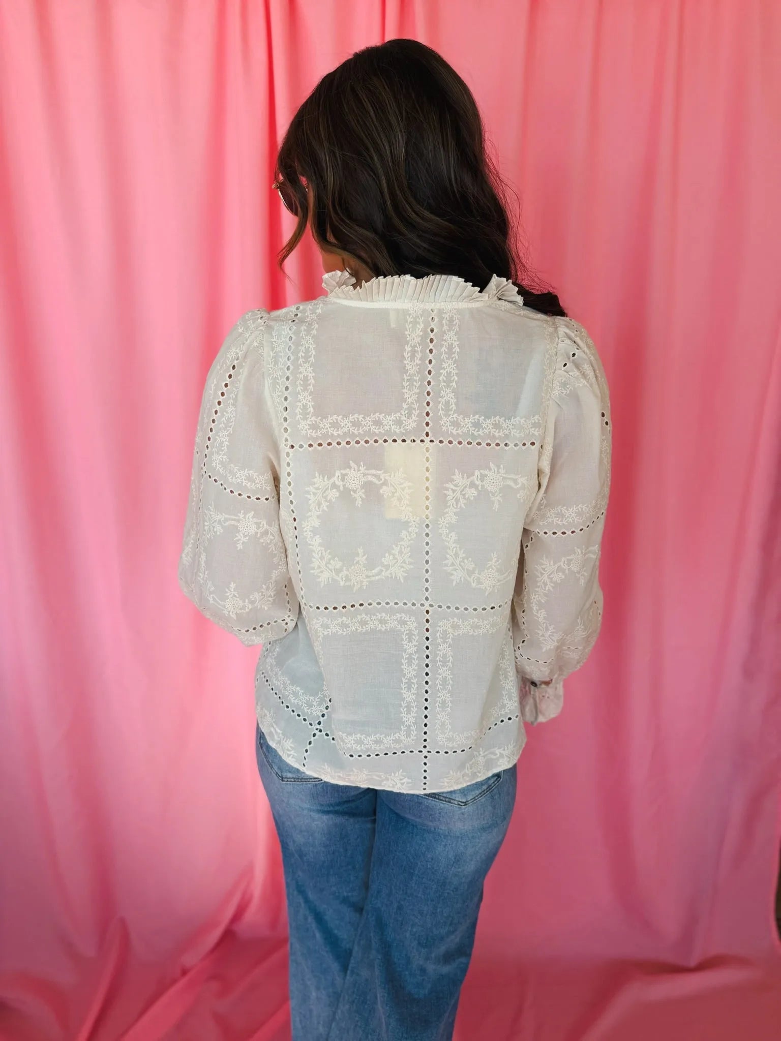 Entro cream eyelet long sleeve blouse, back view. Ruffled neck, puffy sleeves, intricate floral & dotted embroidery.