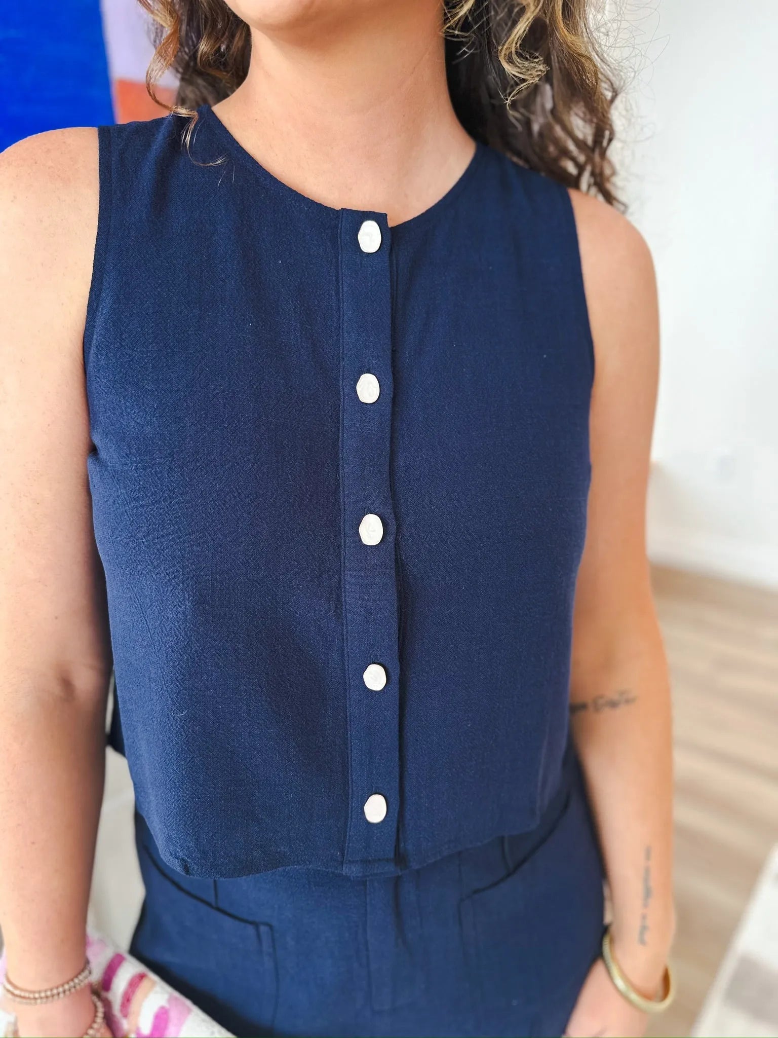 Entro navy sleeveless blouse with a round neckline and white button-down front. Cropped silhouette.