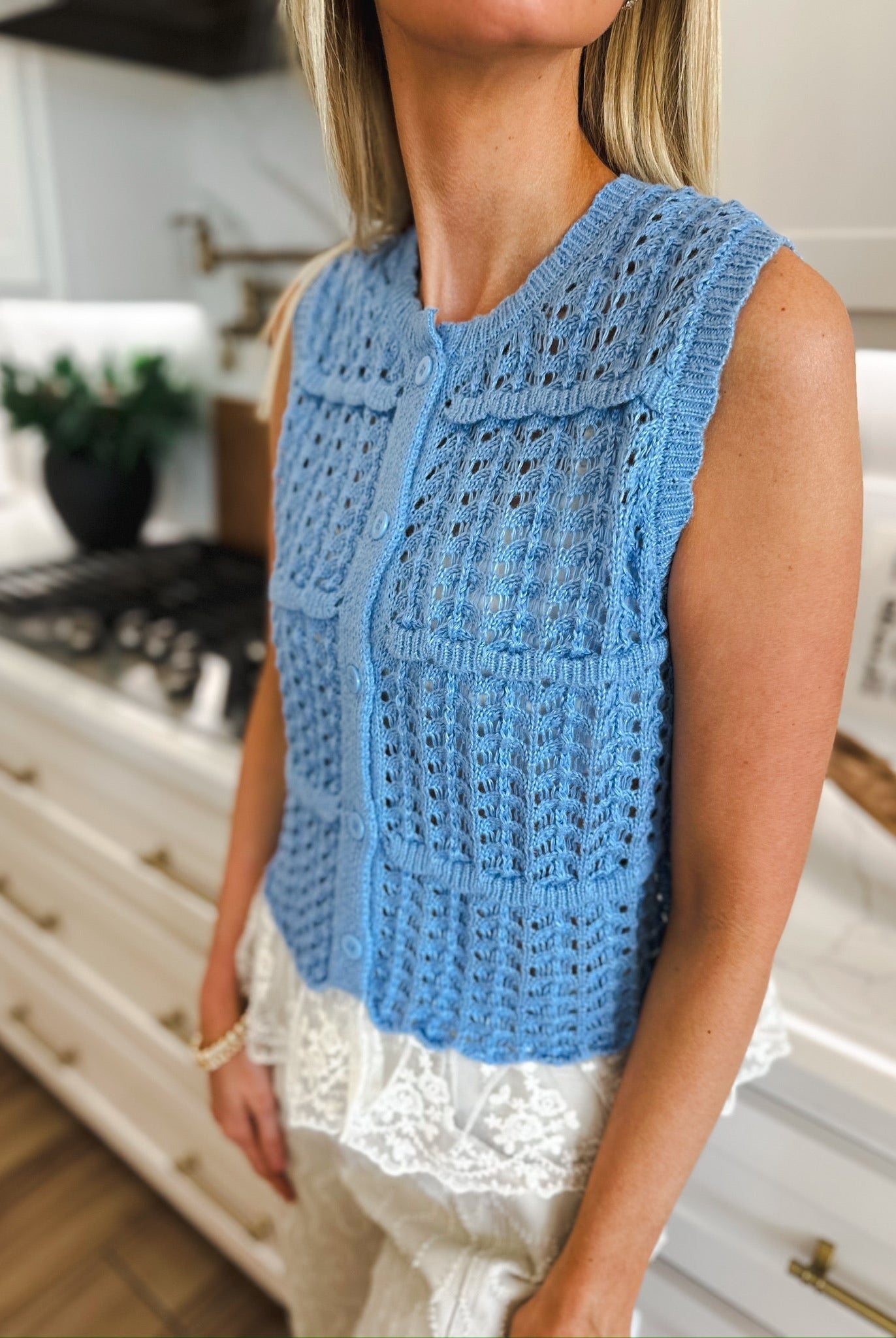 Entro periwinkle blue sleeveless knit cardigan with white lace trim and pearl buttons. Open knit pattern.