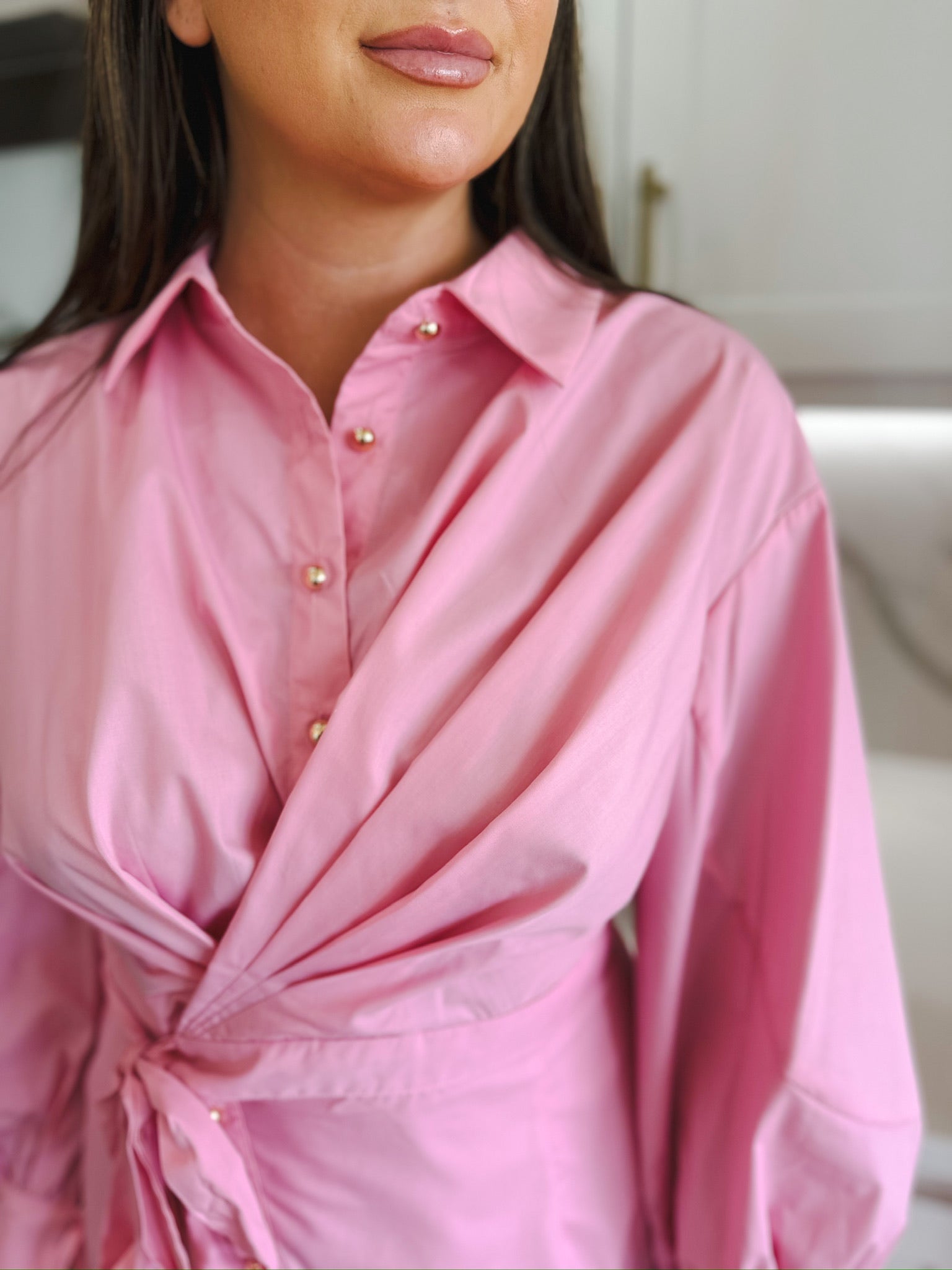 Entro pink dress with gold buttons, collared neckline, draped front, and tie waist detail. Puff sleeves visible.