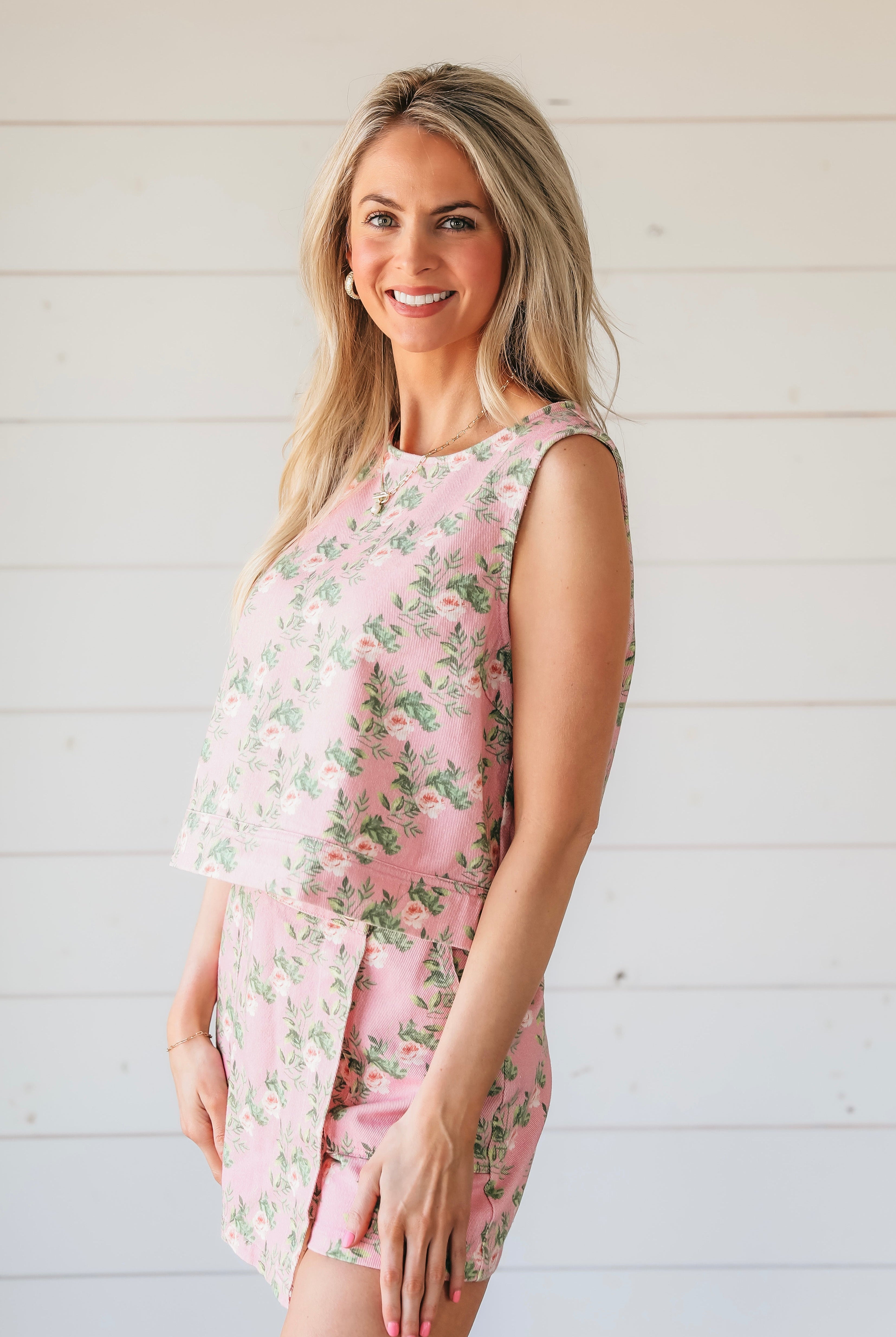 Woman wearing a pink floral print denim skort and matching sleeveless tank top.