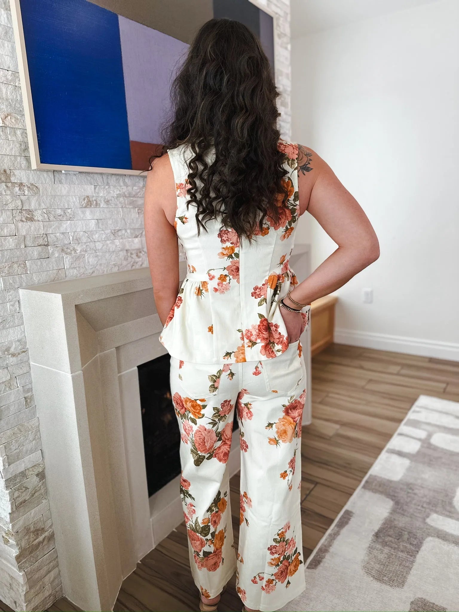 Entro white wide leg jeans and matching peplum top, both with a vibrant floral print of pink and orange roses.