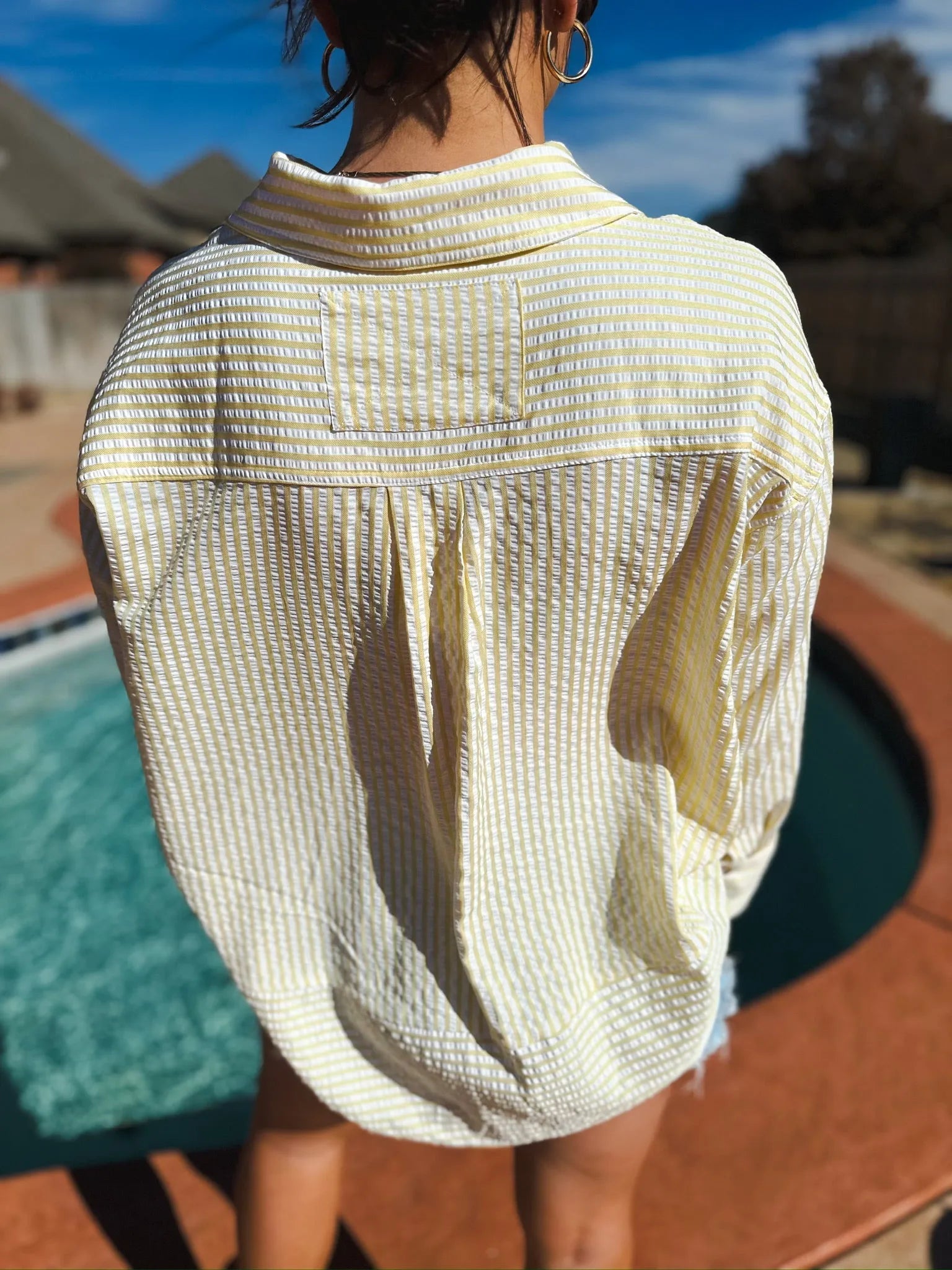 Entro yellow and white striped button-down top, back view, featuring a seersucker texture and pleats below the collar.