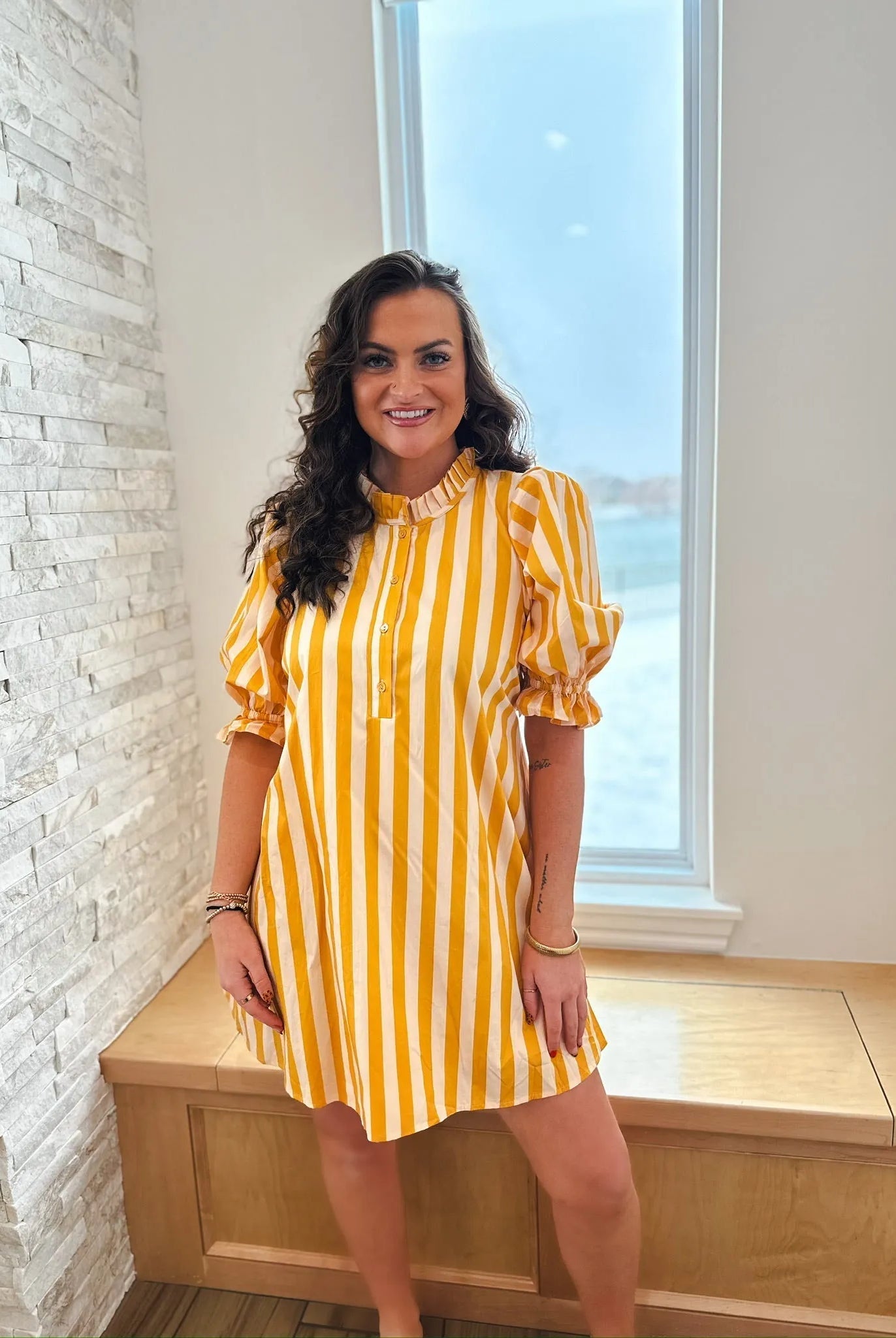 Entro yellow and white vertical striped cotton dress with ruffle neck and puff sleeves, shown on a woman.