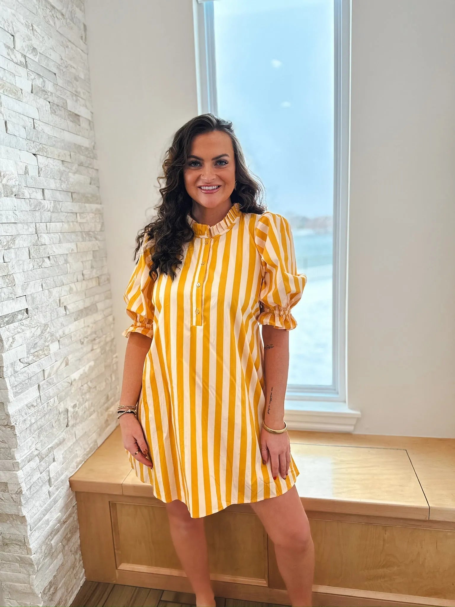 Entro yellow and white vertical striped cotton dress with ruffle neck and puff sleeves, shown on a woman.