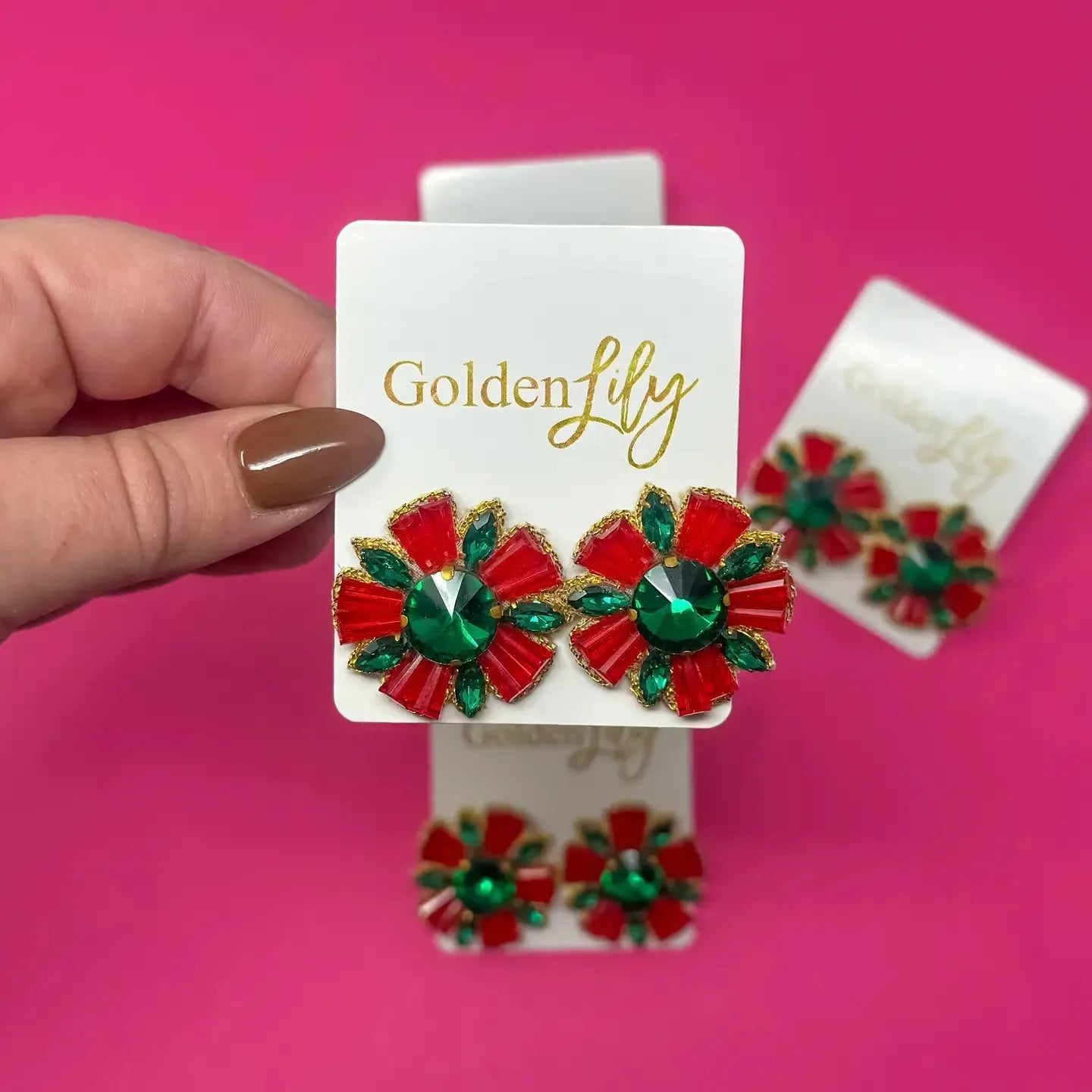 Festive red and green bead burst stud earrings with gold trim, resembling flowers. Clear faceted gemstones in emerald green