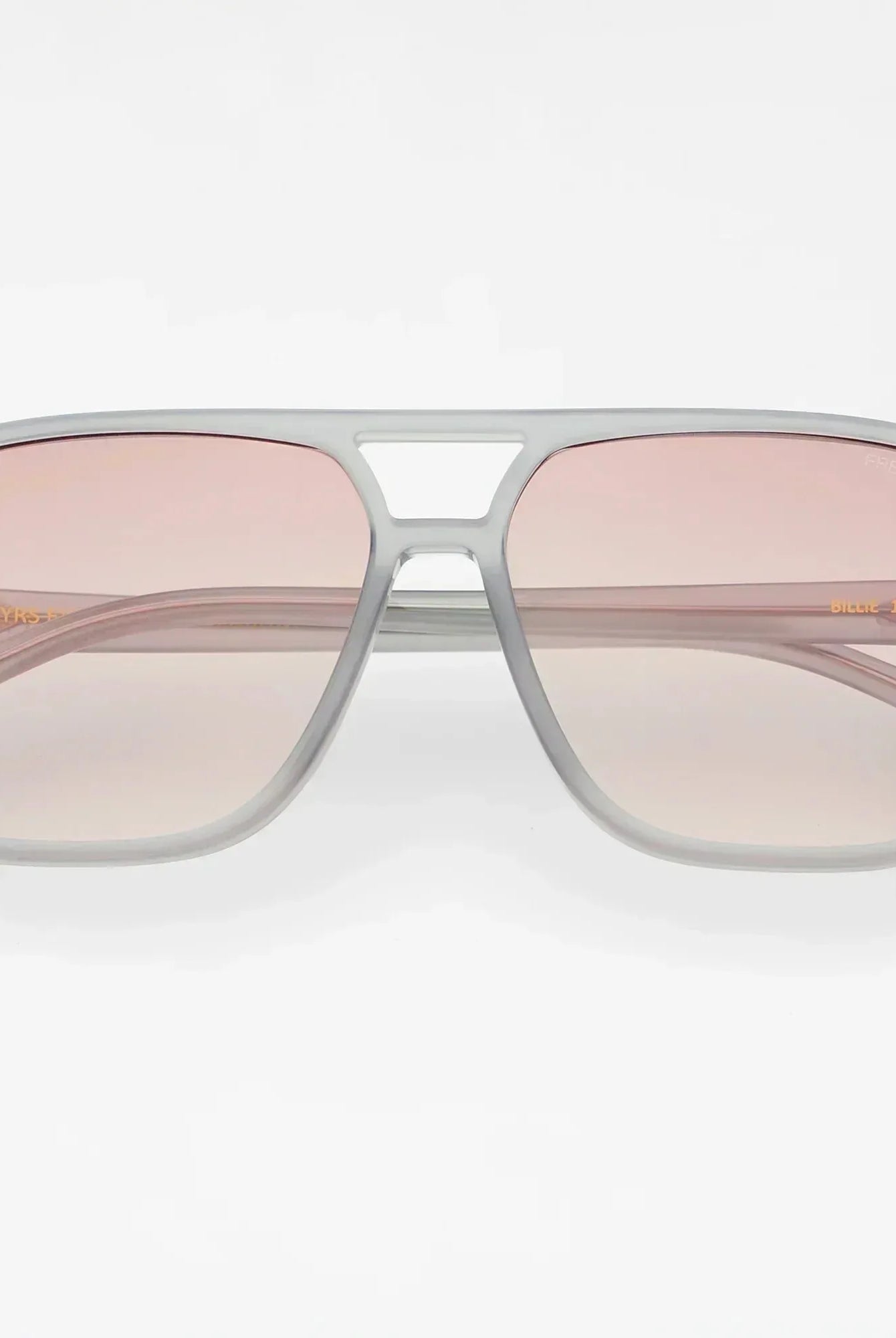 Freyrs Billie Unisex Aviator Sunglasses with light grey frames and gradient pink lenses. Model number "Billie 124-11" is
