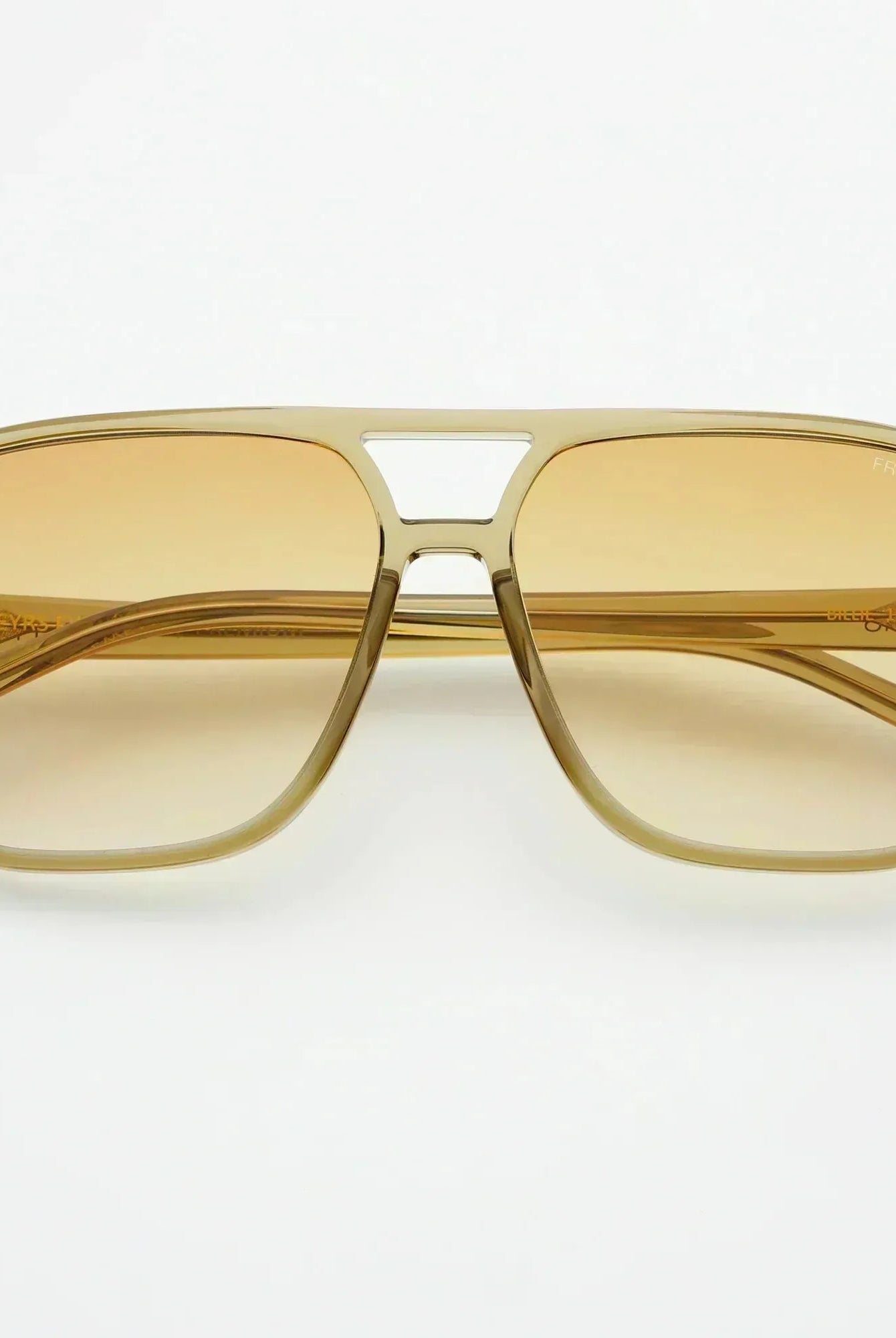 Freyrs Billie unisex aviator sunglasses with amber gradient lenses and translucent beige frames, on a white background.