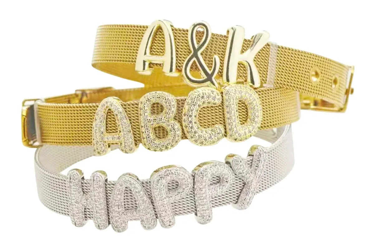 Three slider bracelets: gold mesh with 'A&K' charms, gold mesh with diamond 'ABCD' charms, and silver mesh with diamond