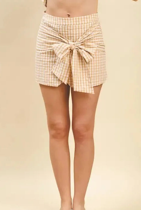 Tan and white gingham print mini skirt with a large bow tie front detail.