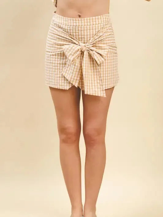Tan and white gingham print mini skirt with a large bow tie front detail.