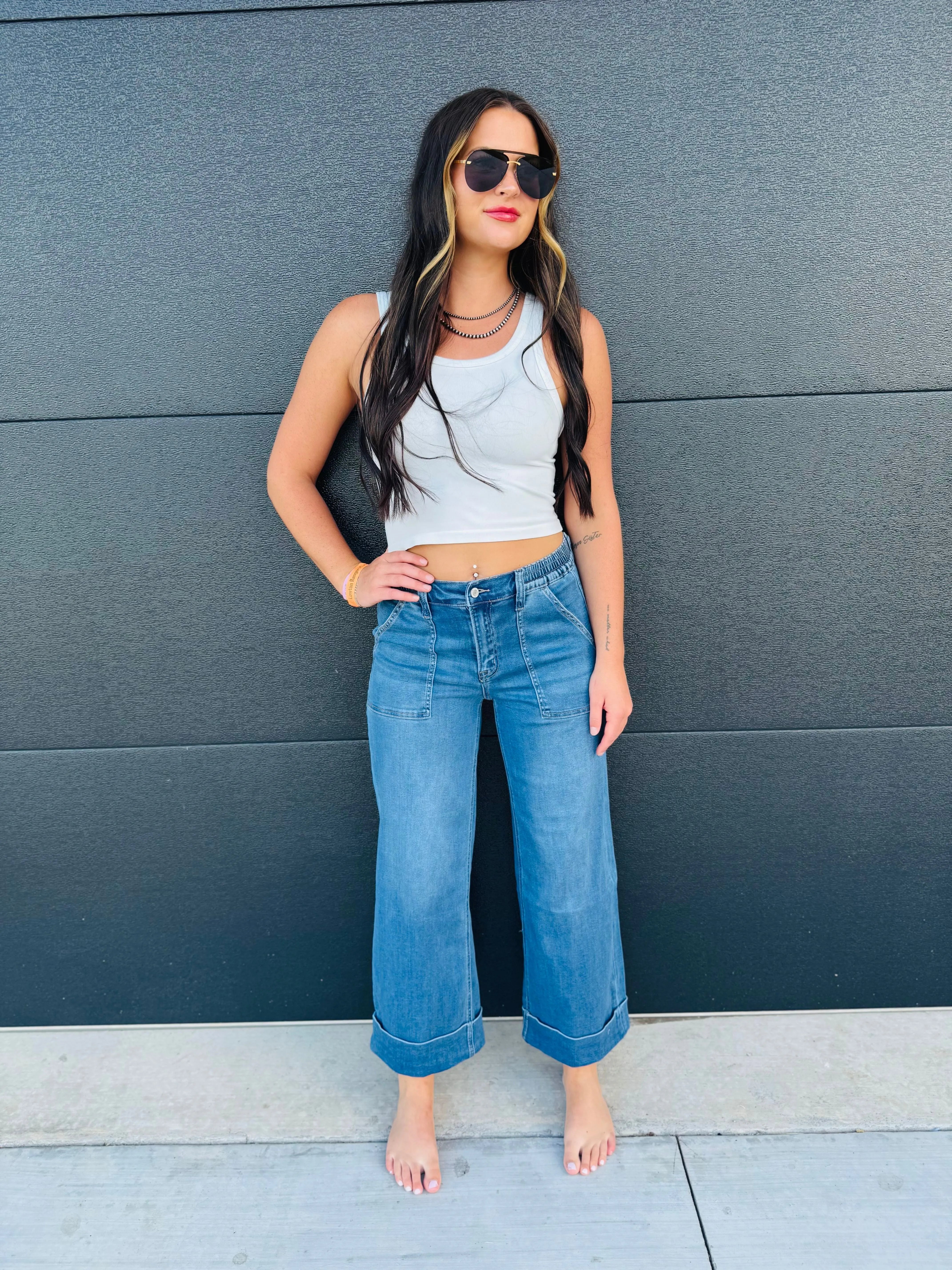 Woman wearing Vervet high rise baggy wide leg jeans with double cuffs. Light wash denim, cropped length.