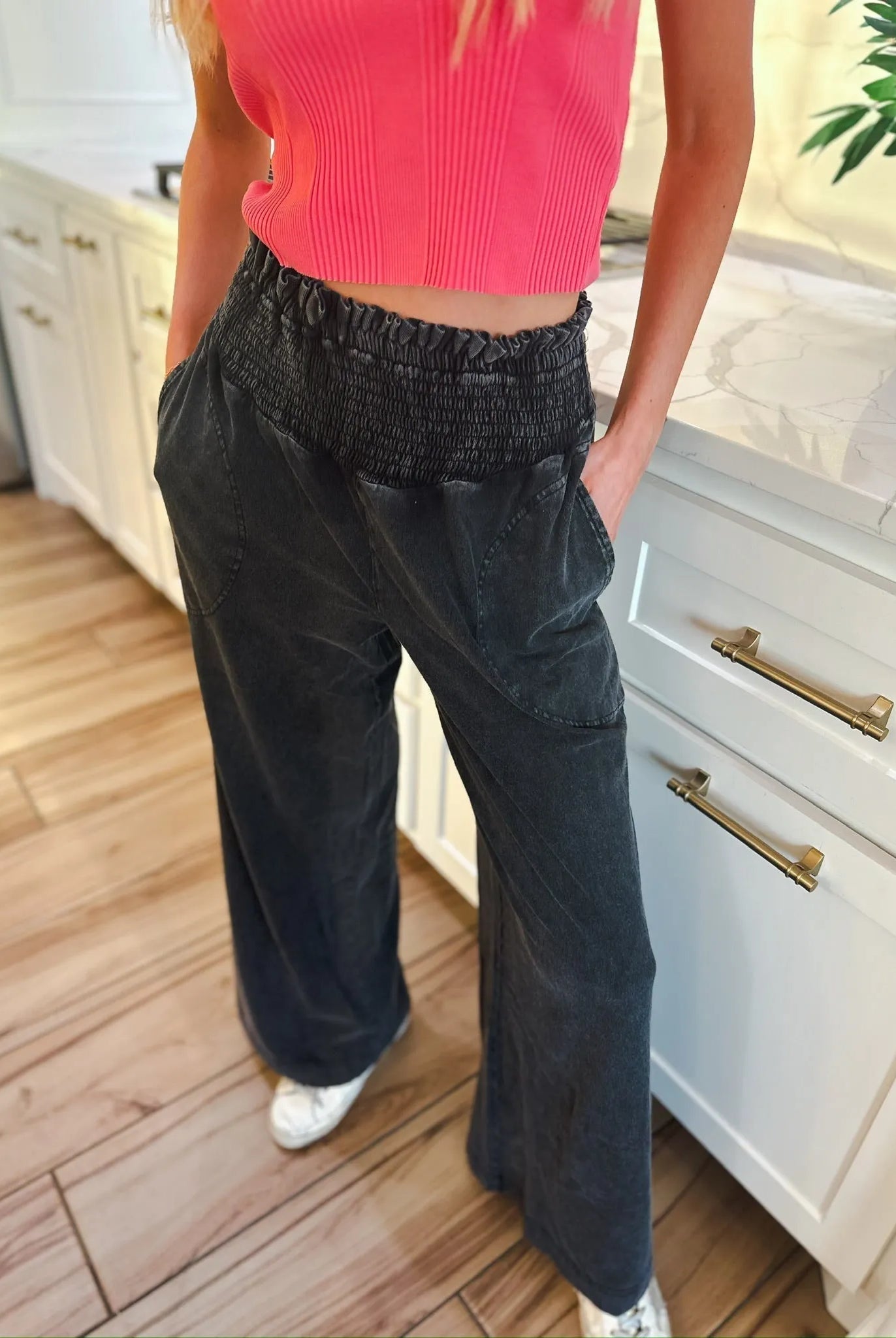 Woman wearing HyFVE black wash elastic waist wide leg trousers with pockets and a pink crop top.