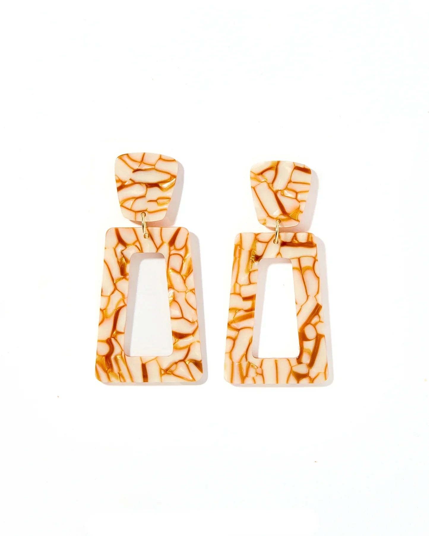 Kennedy statement earrings in desert sand color, featuring a cream base with irregular brown marbled patterns and a hollow