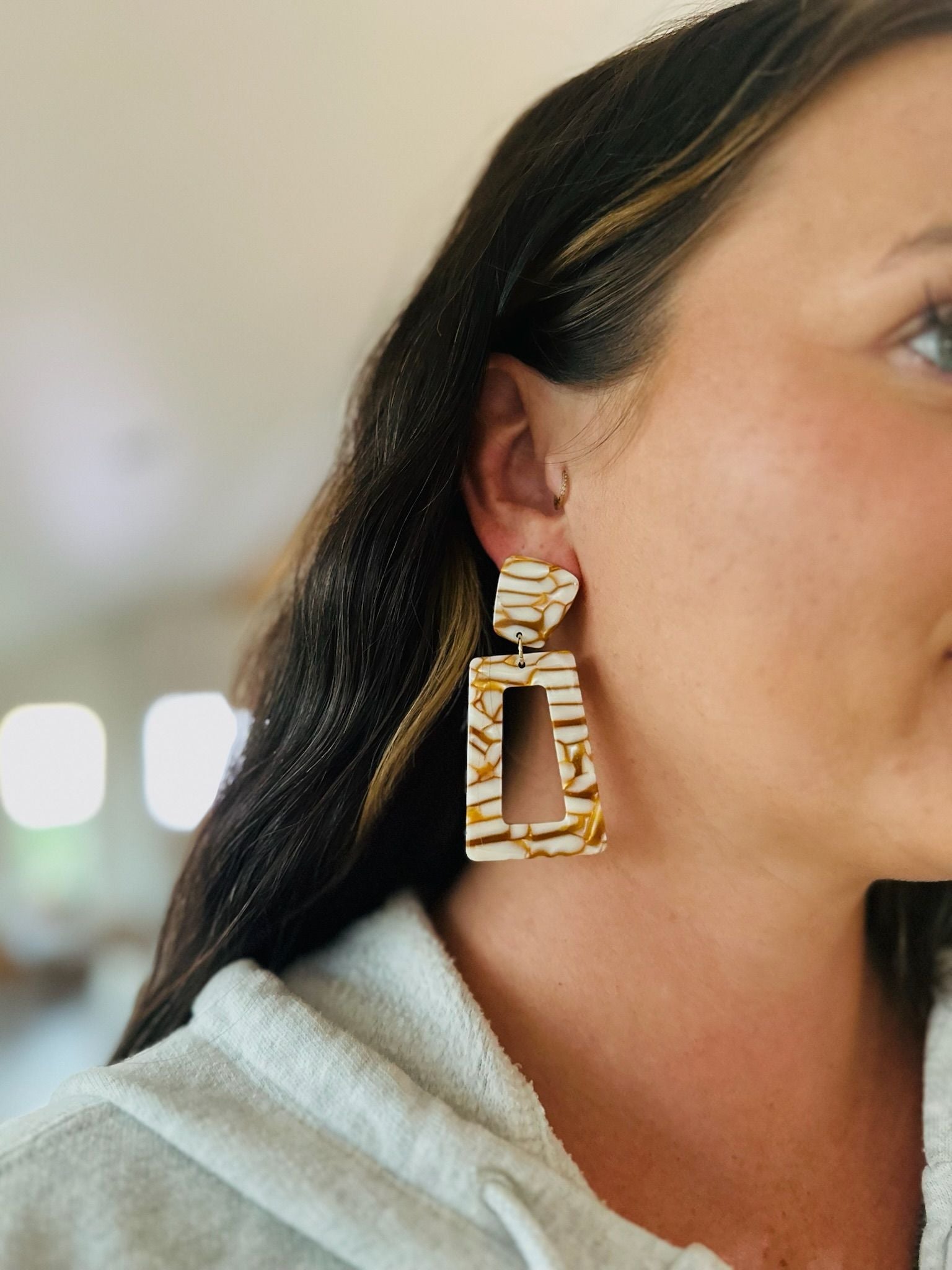 Kennedy statement earrings in desert sand color. Abstract marbled pattern in gold and white. Rectangular dangle earrings.