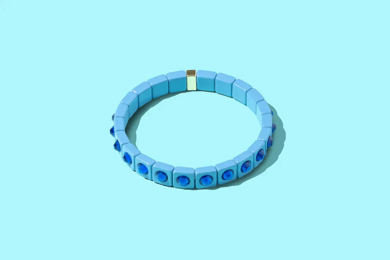 Light blue enamel bracelet with square beads and deep blue square stone accents, connected by a gold clasp.