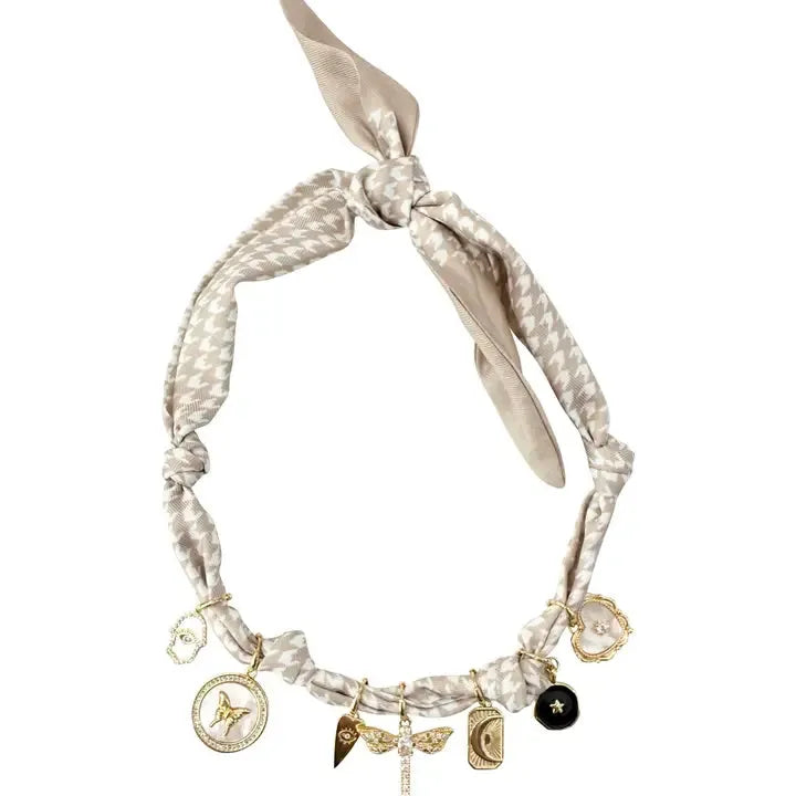 Mallory Scarf Necklace with houndstooth pattern, featuring multiple gold charms including a butterfly, dragonfly, moon, and