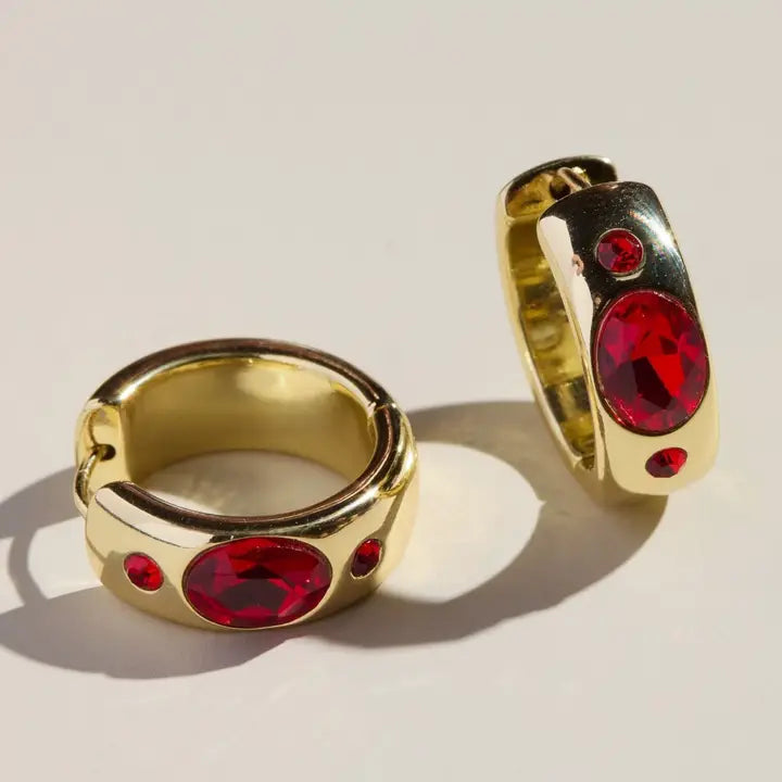 Gold hoop earrings with red oval CZ stones and small red accent stones in a bezel setting.
