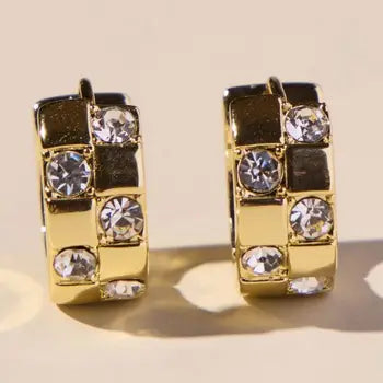 Nickel & Suede gold pavé checkered huggie earrings with clear sparkling stones set in a checkerboard pattern.