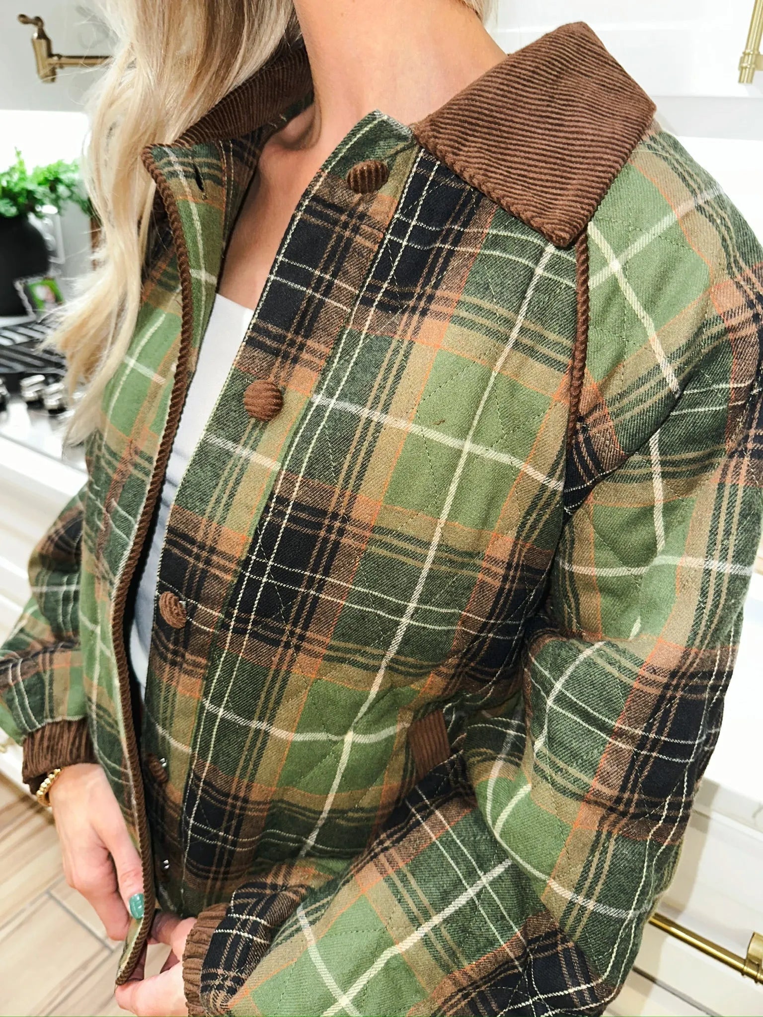 Green quilted plaid puffer jacket with brown corduroy collar and trim, featuring button closure.