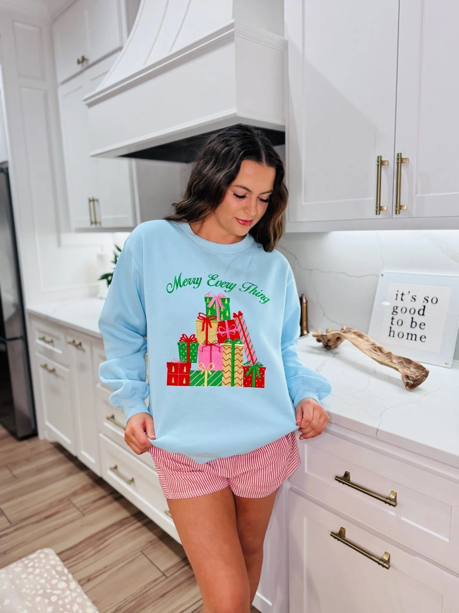 Light blue "Merry Every Thing" sweatshirt with a graphic of stacked colorful Christmas presents.