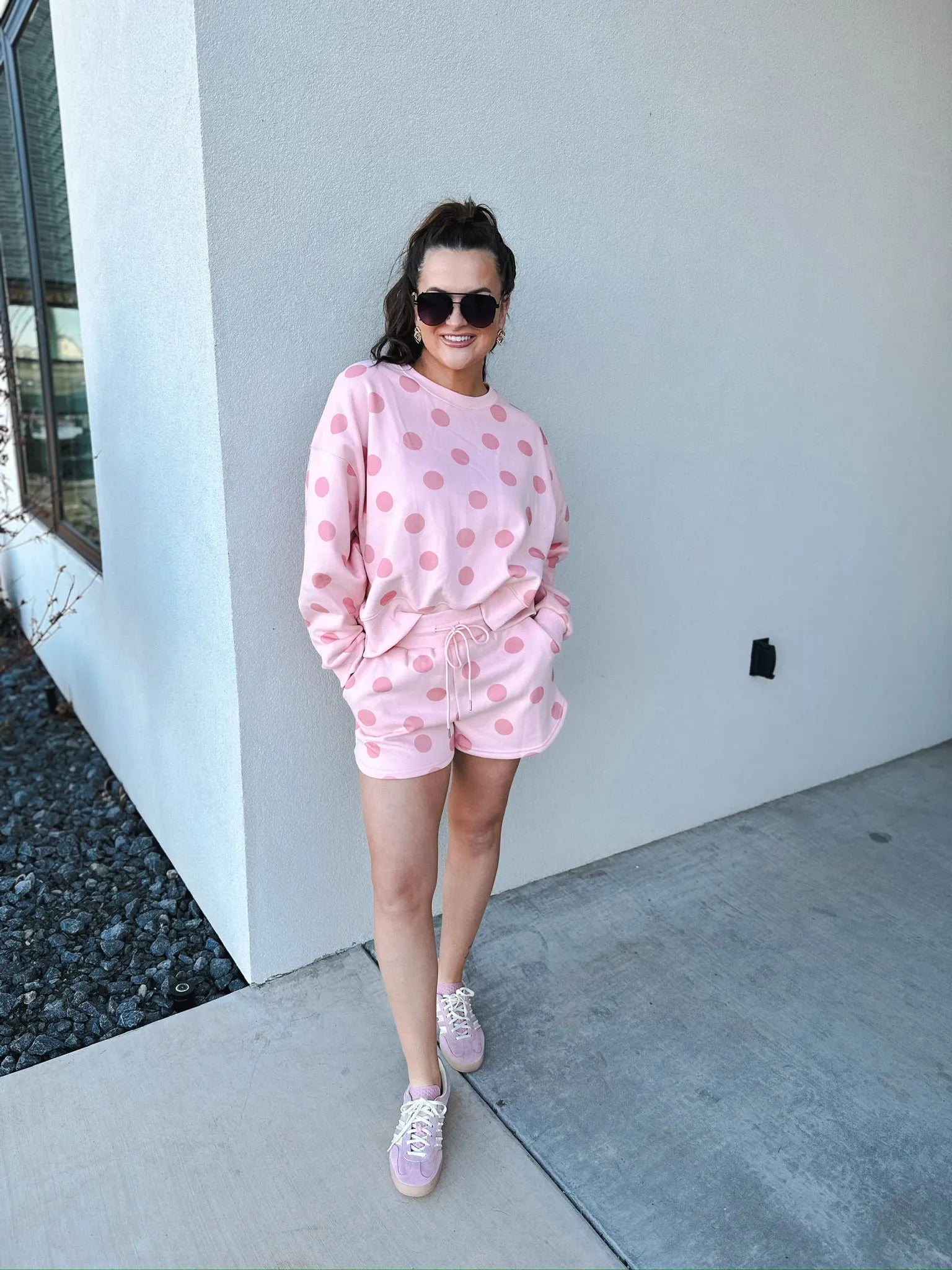 Poppy & Pine blush pink polka dot sweatshirt and matching shorts set on a woman wearing sunglasses and sneakers.