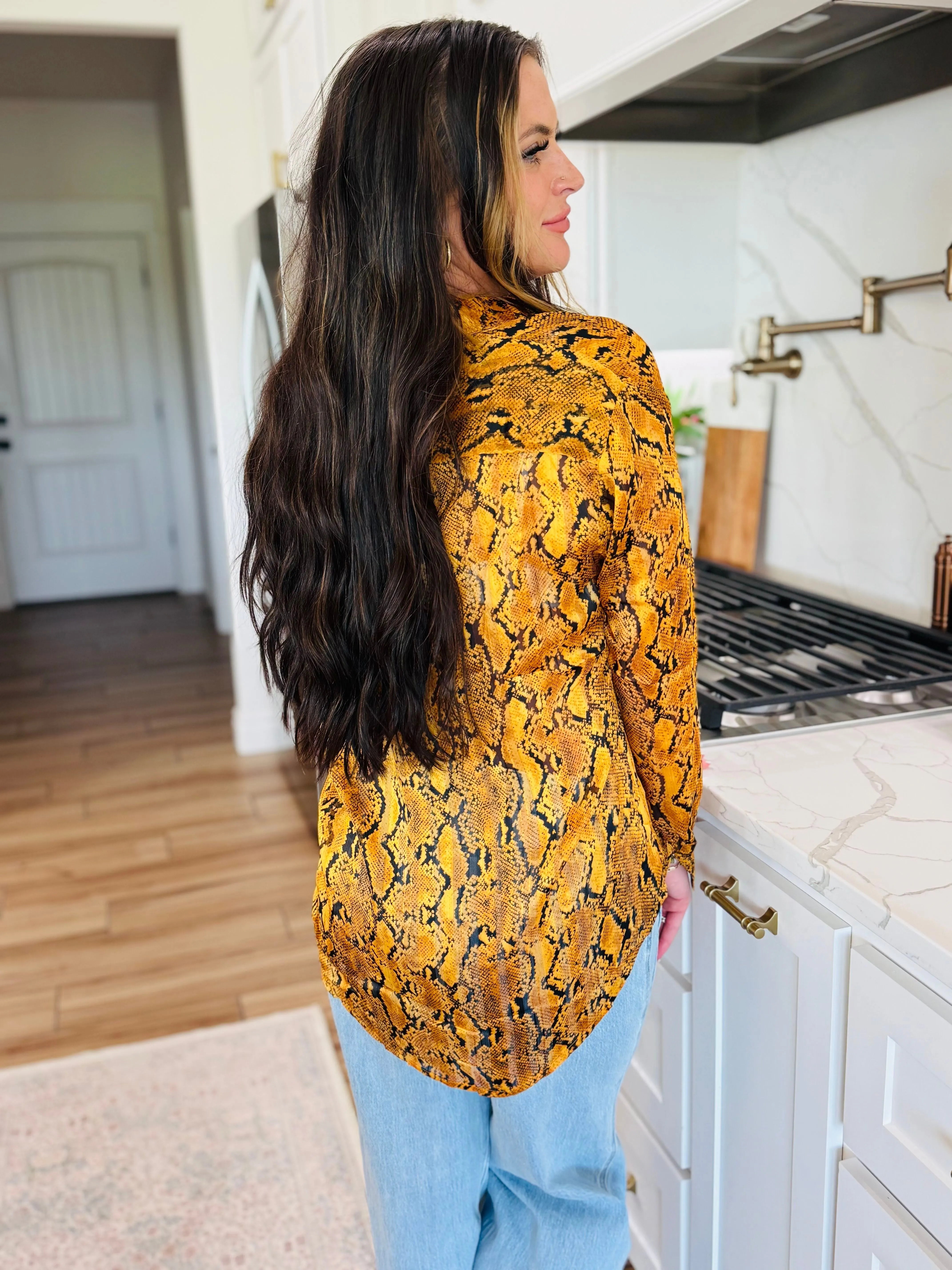 Portia yellow snake print button-up blouse on a woman, featuring a long-sleeved, collared design with a bold snake pattern.