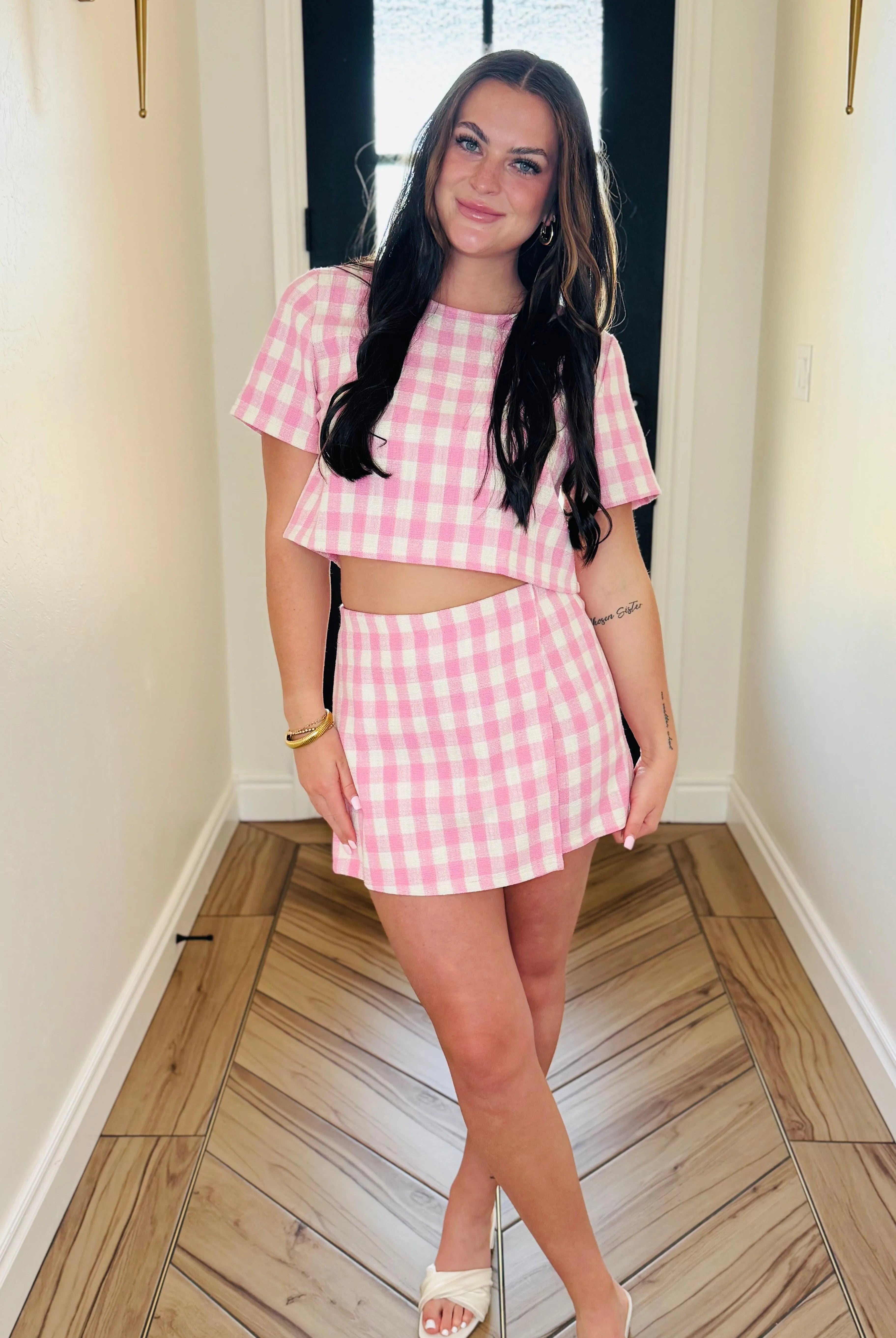 Woman in pink gingham skort set. Short sleeve crop top and mini skirt with hidden zipper closure. Fashion style.
