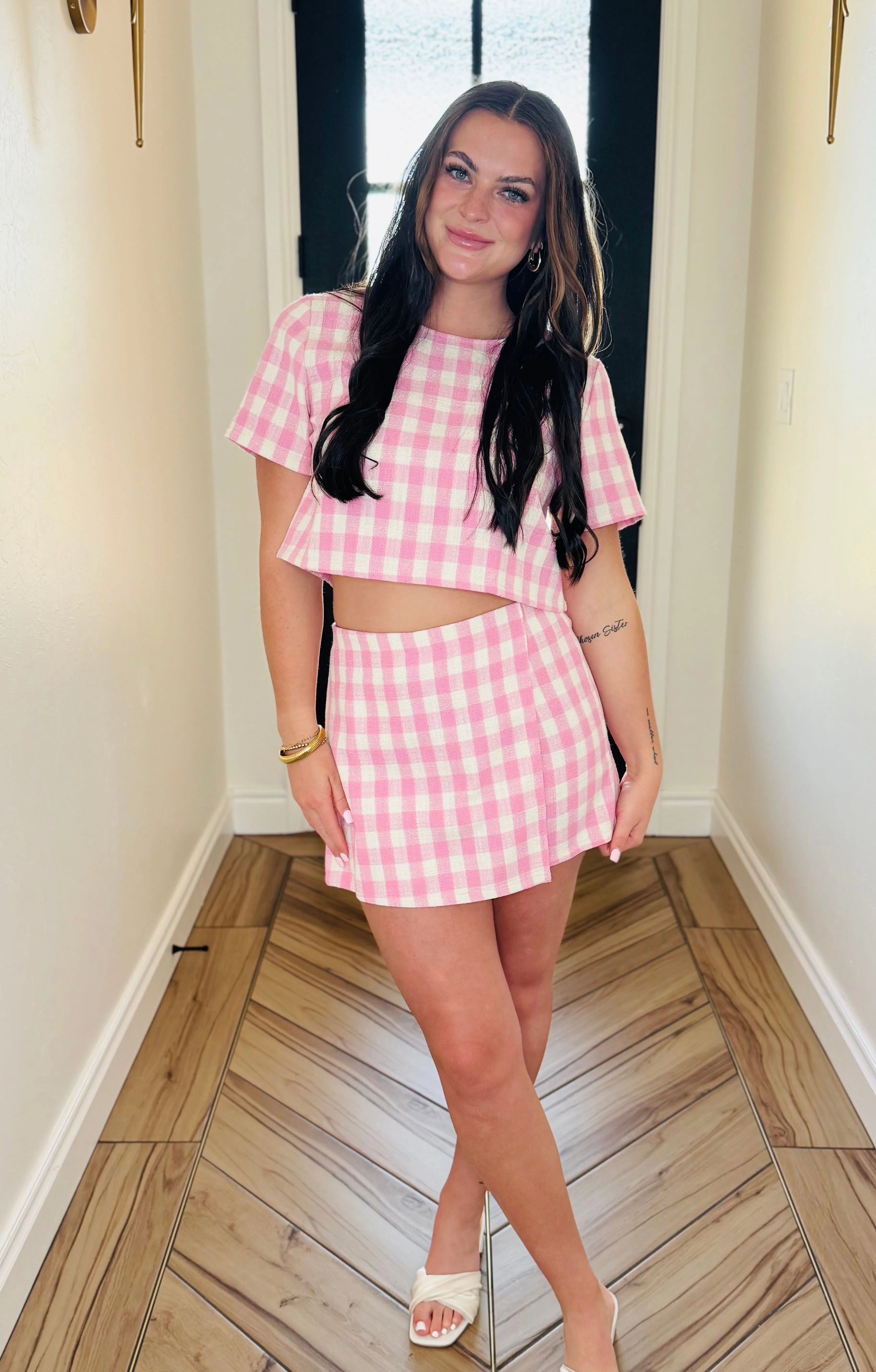 Woman in pink gingham skort set. Short sleeve crop top and mini skirt with hidden zipper closure. Fashion style.
