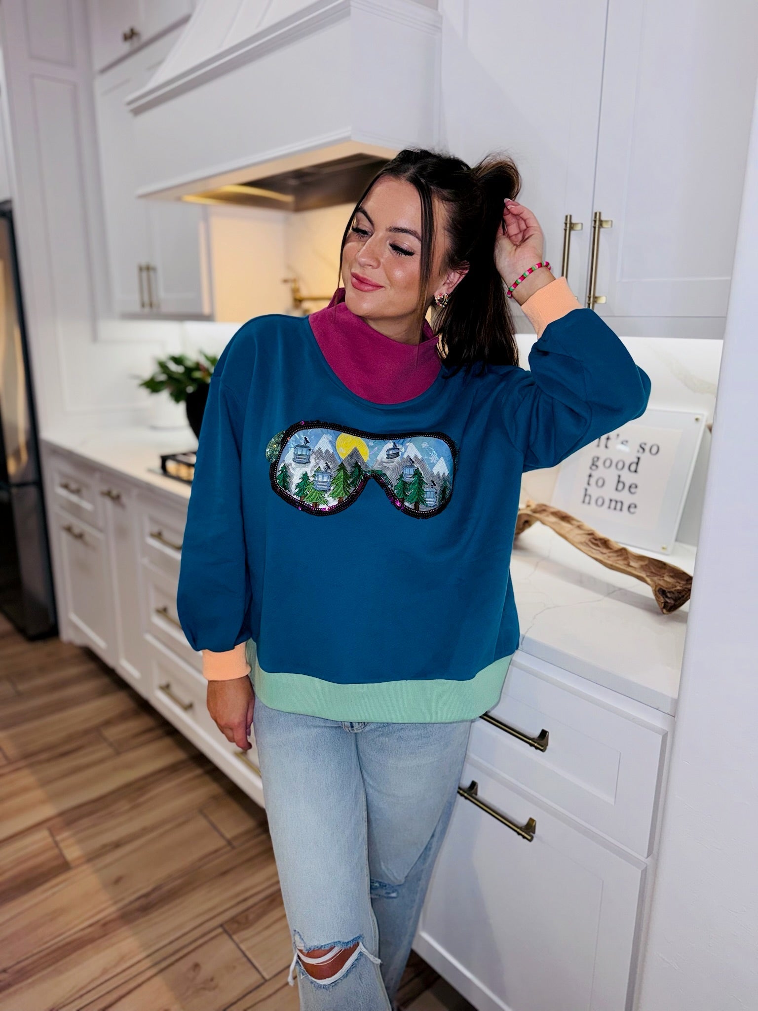 QOS Colorblock Ski Goggle Sweatshirt: Teal sweatshirt with pink mock neck, ski goggles graphic with mountains, trees, sun