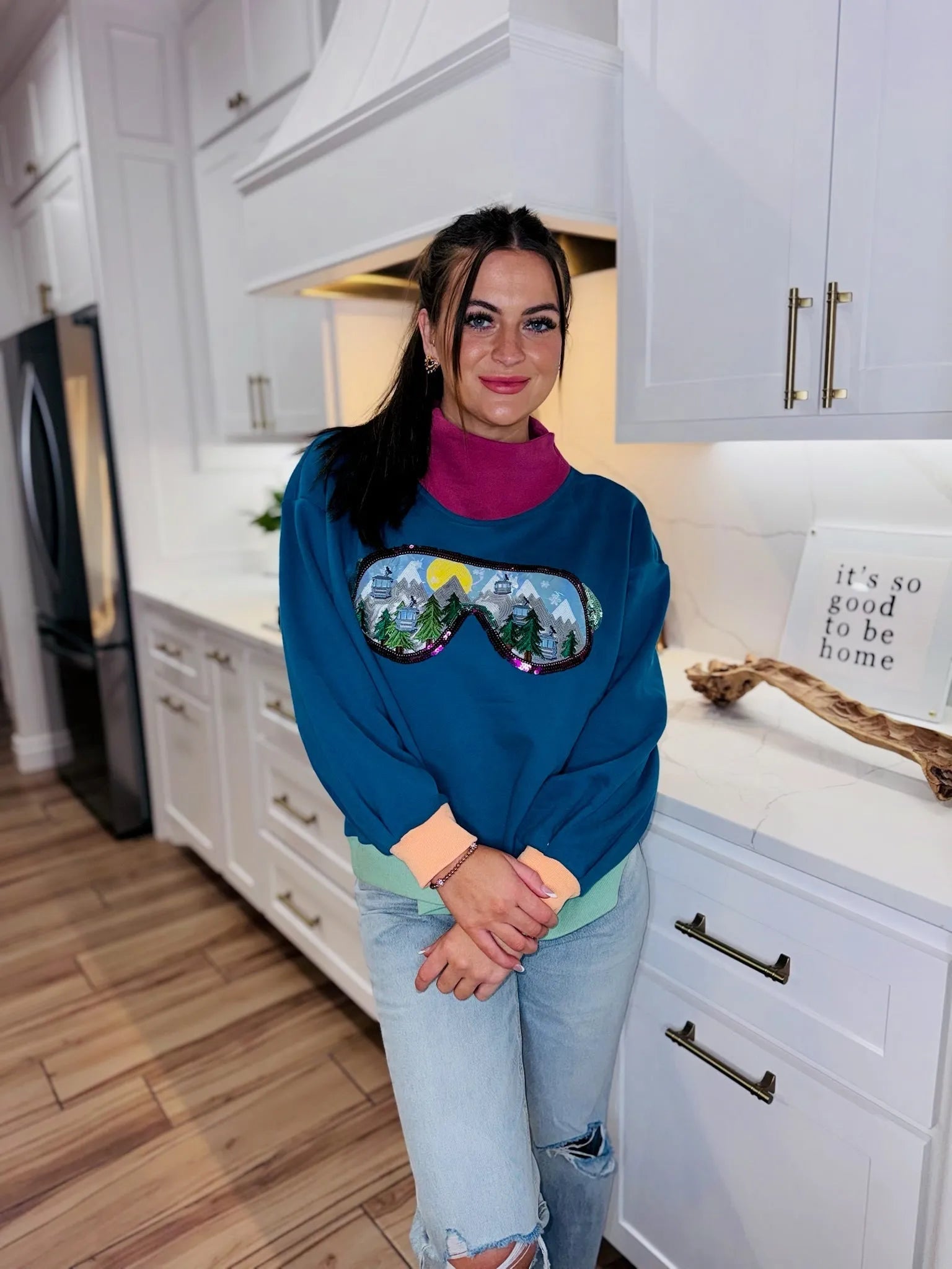 QOS Colorblock Ski Goggle Sweatshirt with mountain scene graphic, teal, pink, light green, and orange accents. Woman