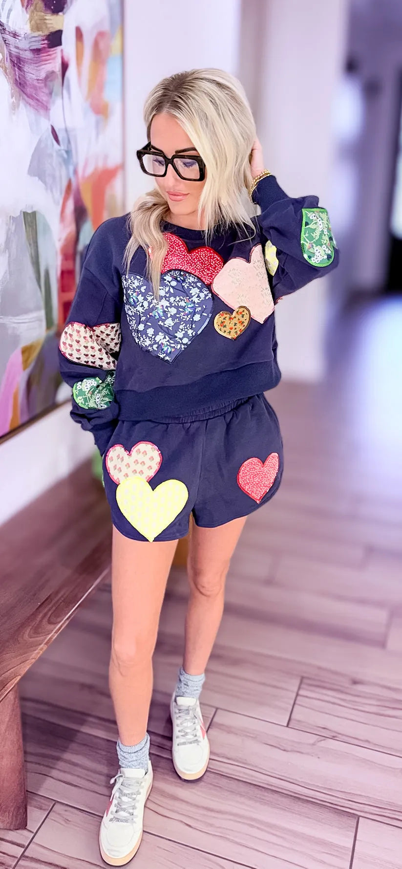 Navy jogger shorts and matching sweatshirt adorned with various colorful embroidered heart patches. Queen of Sparkles.