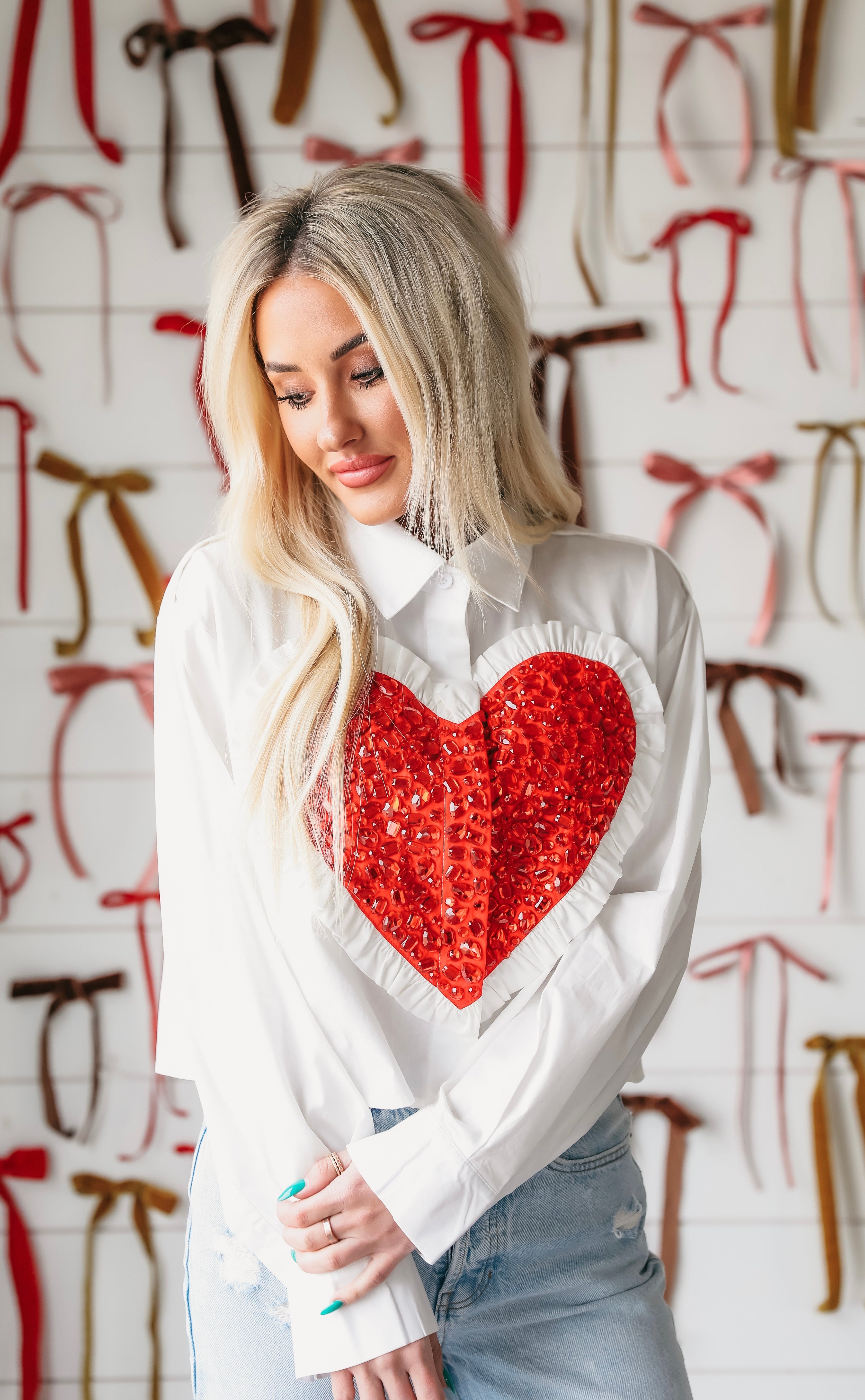 Queen of Sparkles white button-down shirt with a large, sequined red heart applique on the chest and ruffled trim.